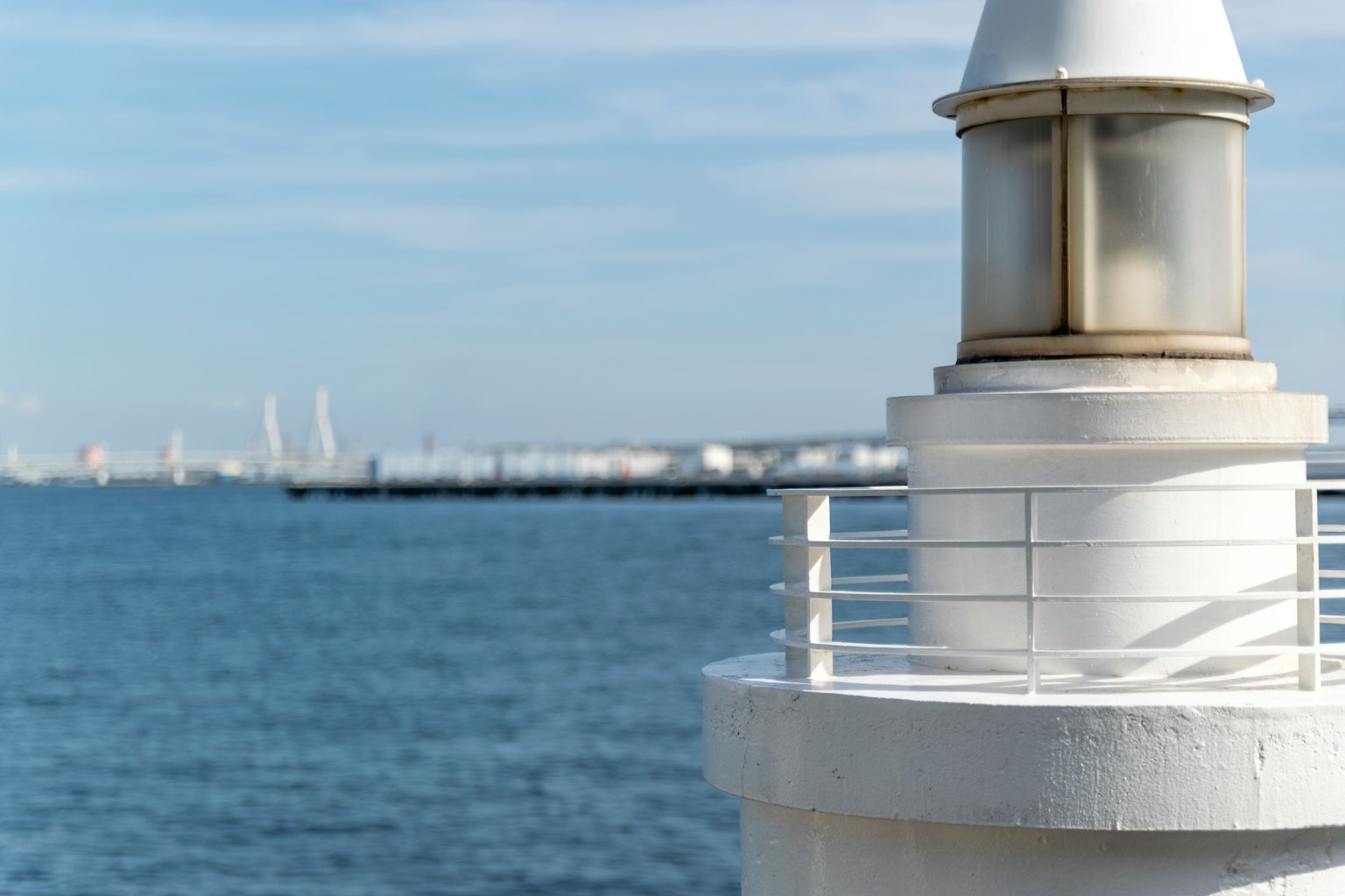 Acercamiento de un faro blanco con el océano al fondo