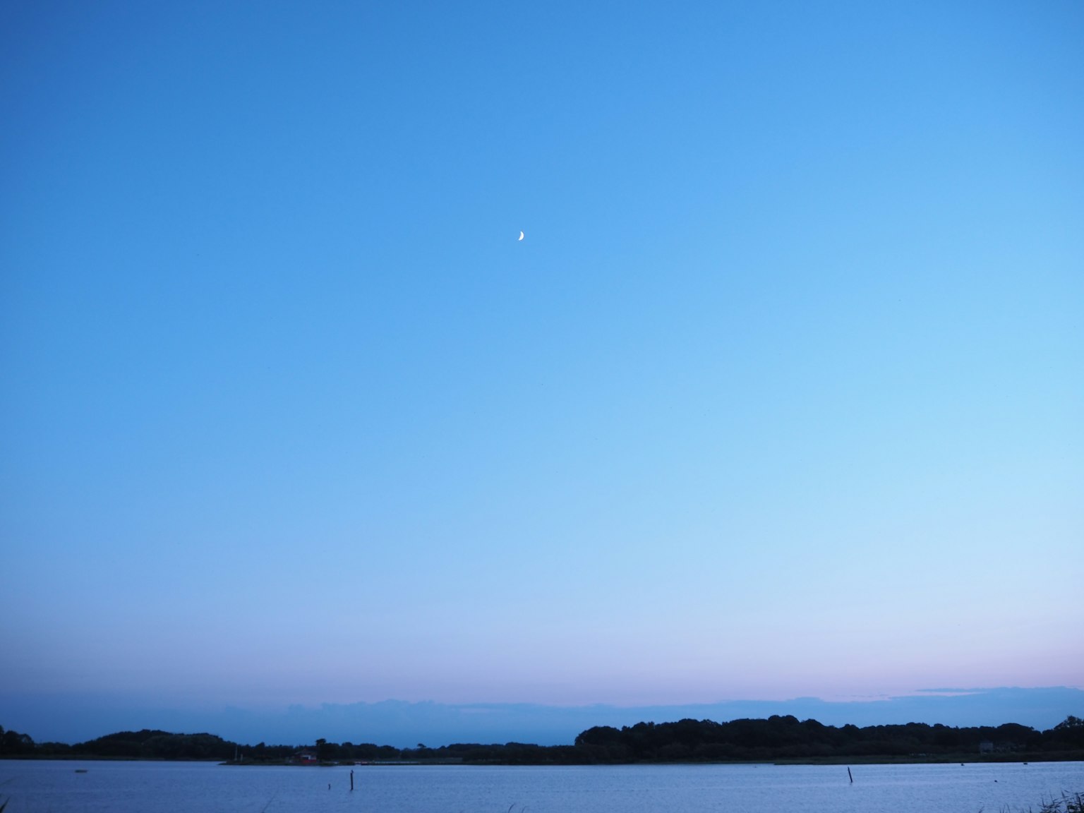 Serene blue sky with a visible moon
