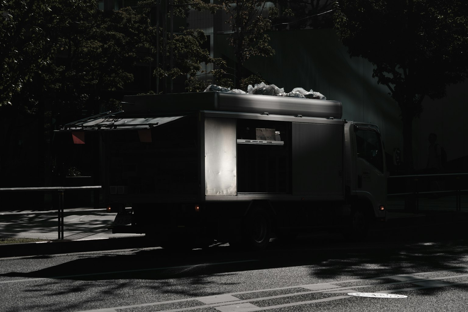 Silhouette di un camion di cibo parcheggiato su uno sfondo scuro