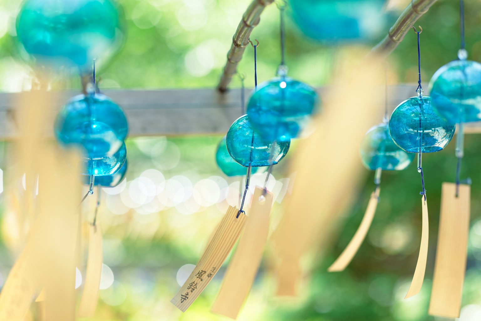 Hình ảnh của những chiếc chuông gió màu xanh treo với dải giấy vàng