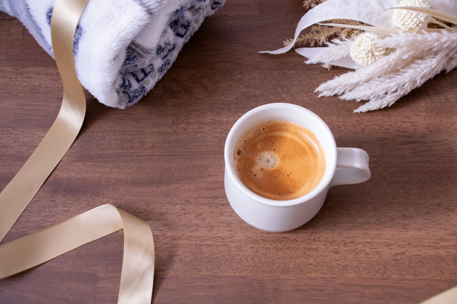 Expresso dans une tasse blanche avec une couverture confortable et un ruban décoratif