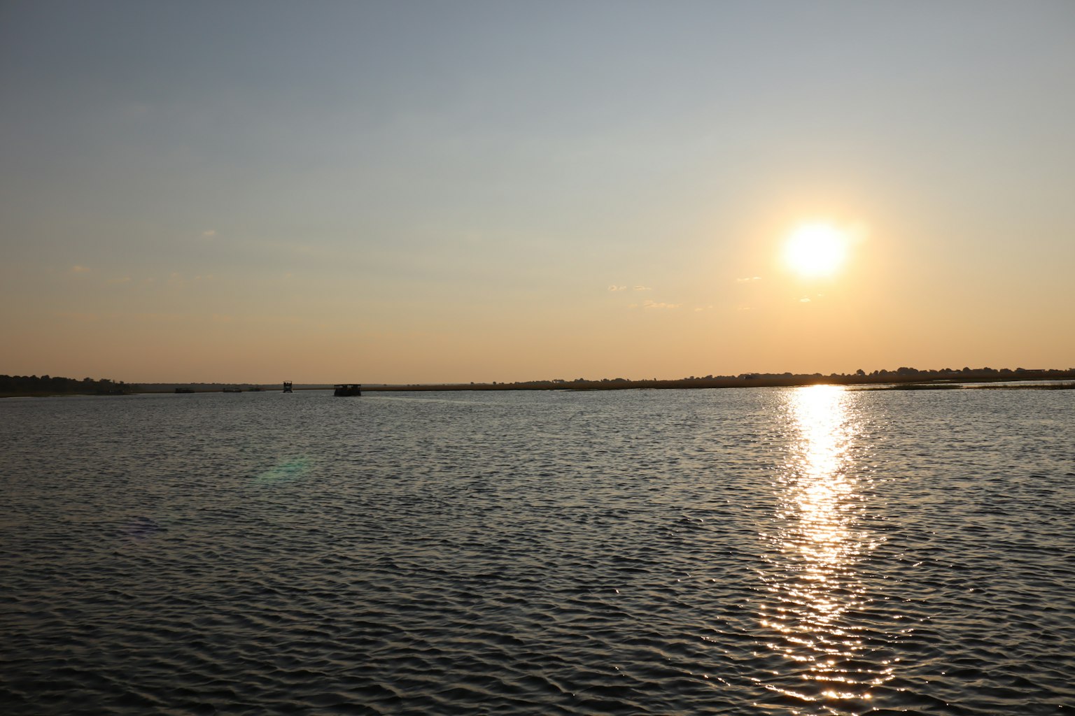 Ruhiges Wasser, das den Sonnenuntergang mit der umliegenden Landschaft spiegelt