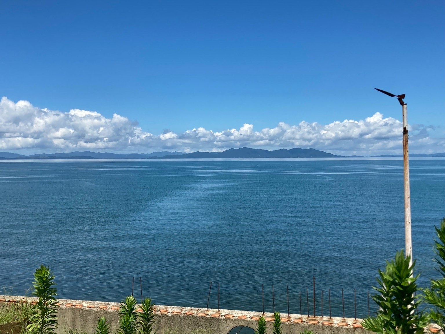 蓝色海洋和天空的风景，远处有云和岛屿
