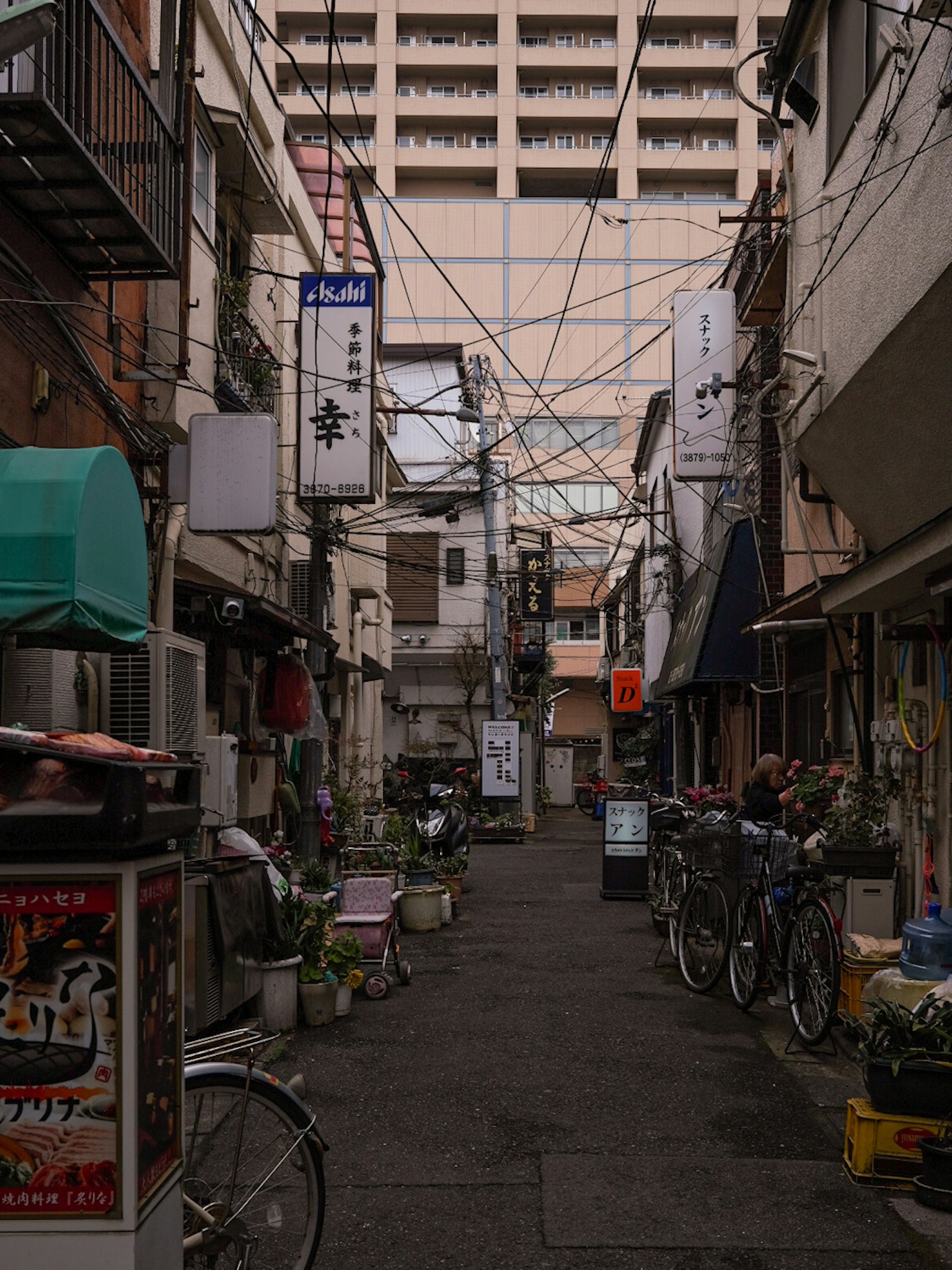 狭い路地に並ぶ店舗と自転車が見える街並み