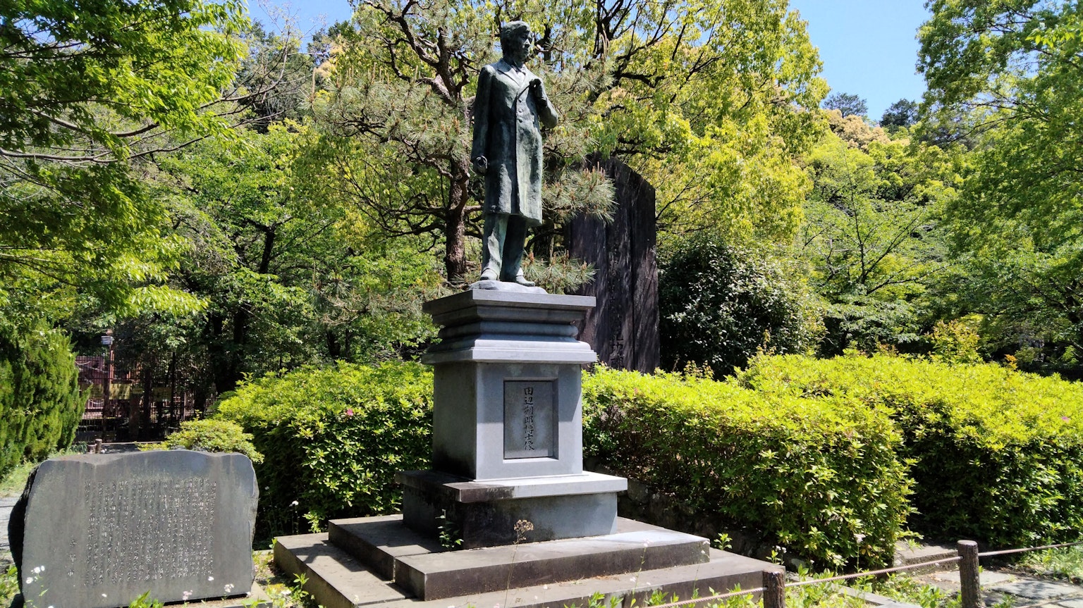 Bronze statue in a green park surrounded by trees