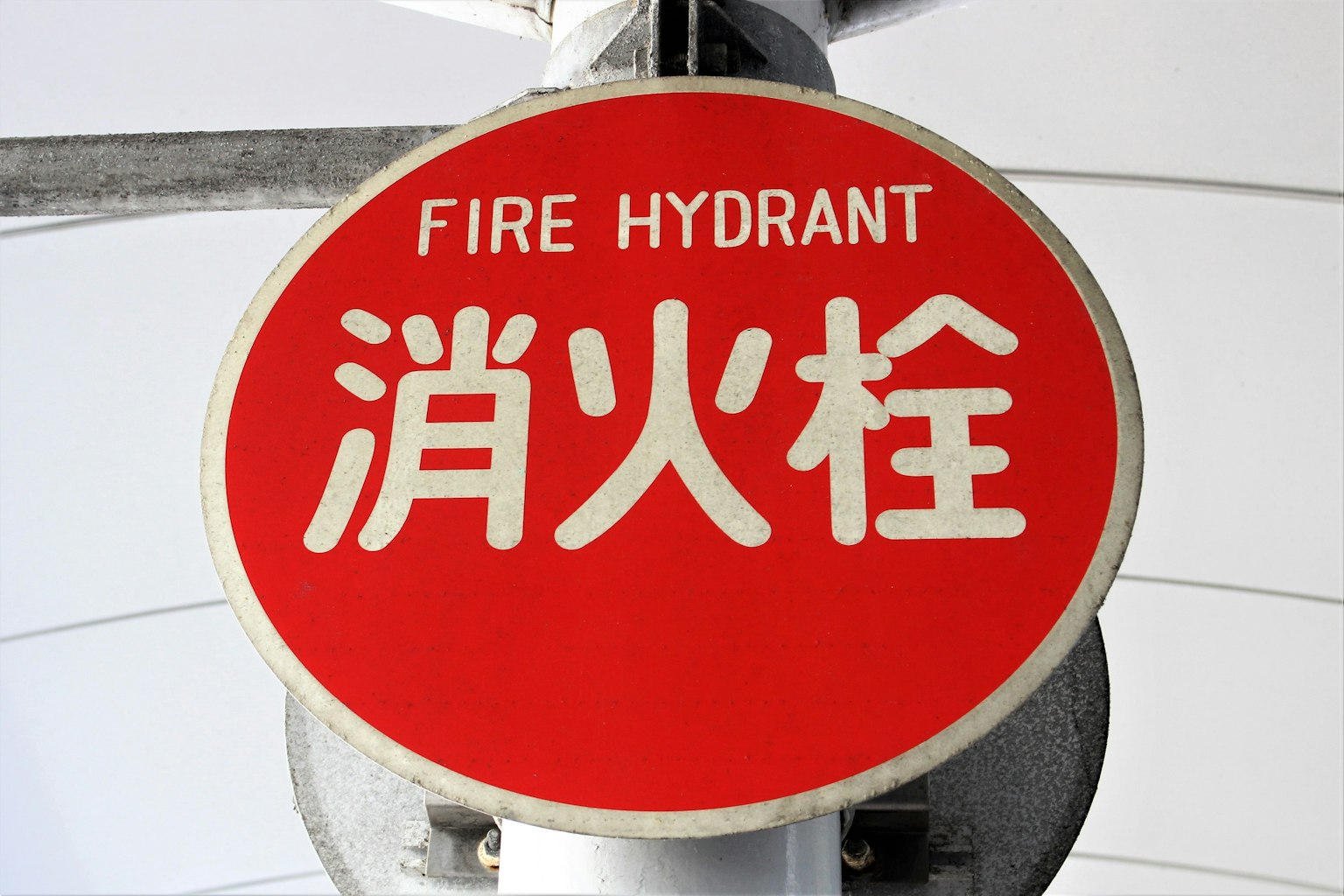 Señal roja de hidrante con caracteres en inglés y chino