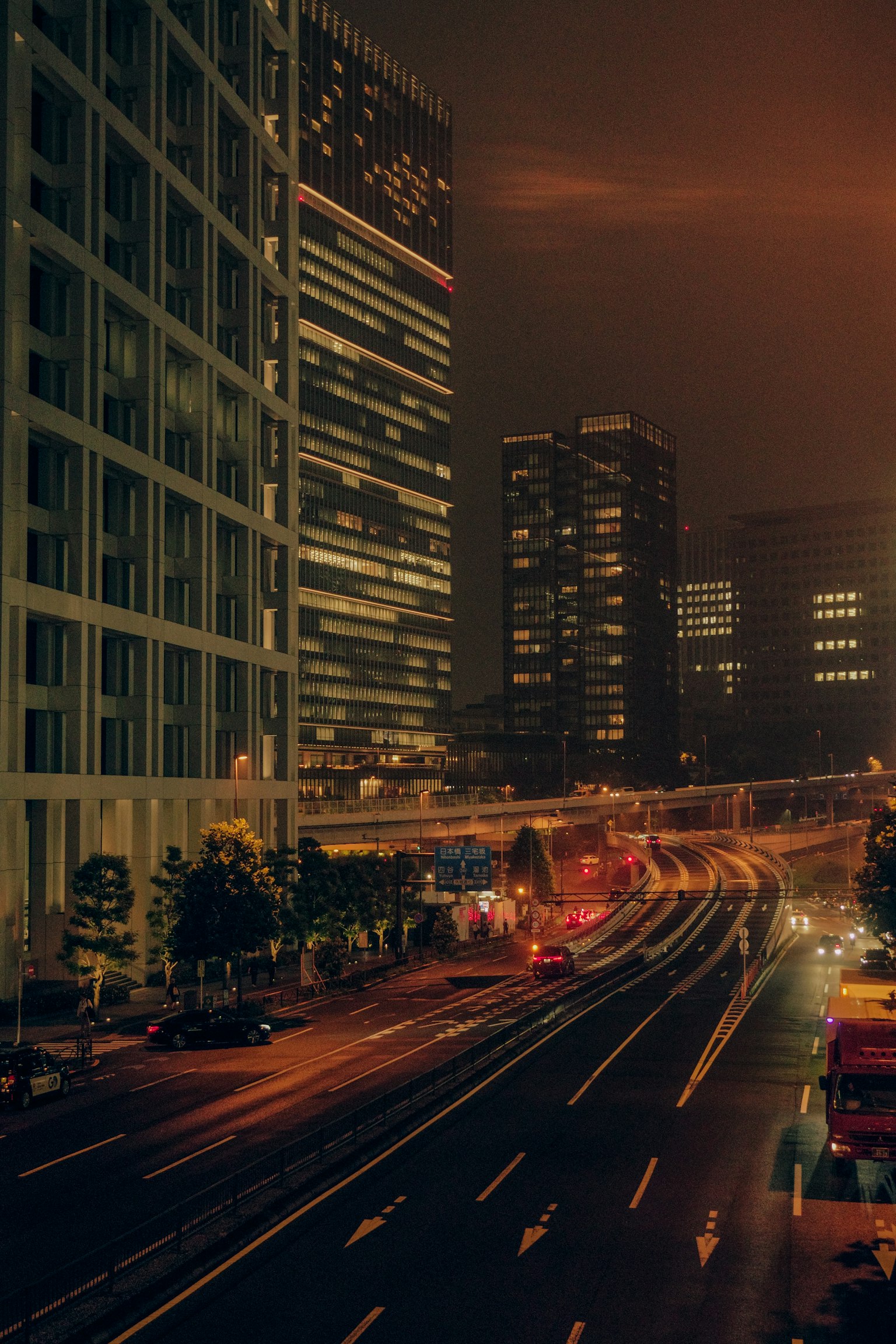 Night cityscape featuring tall buildings and flowing traffic