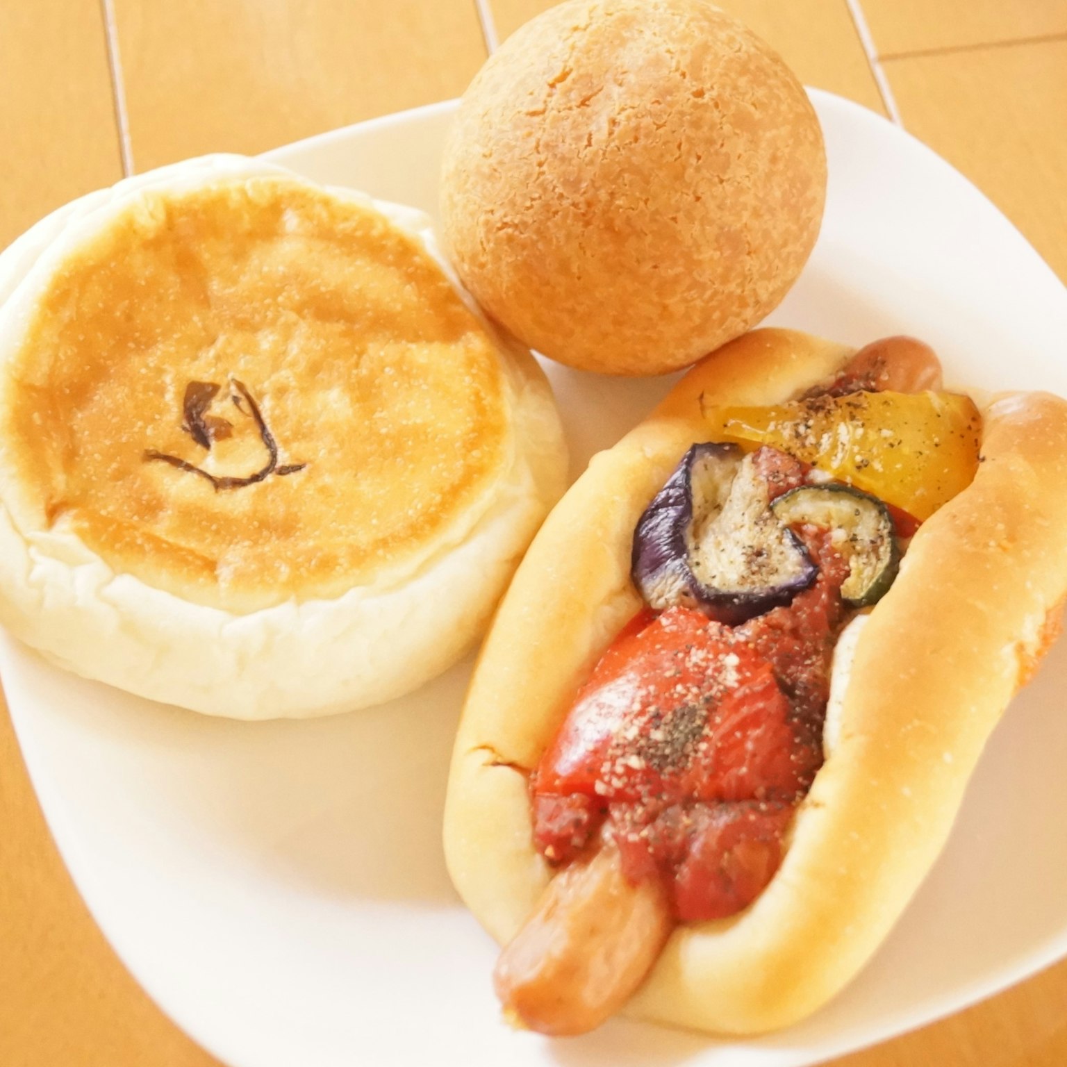 Un piatto con un hot dog guarnito di verdure e un panino rotondo