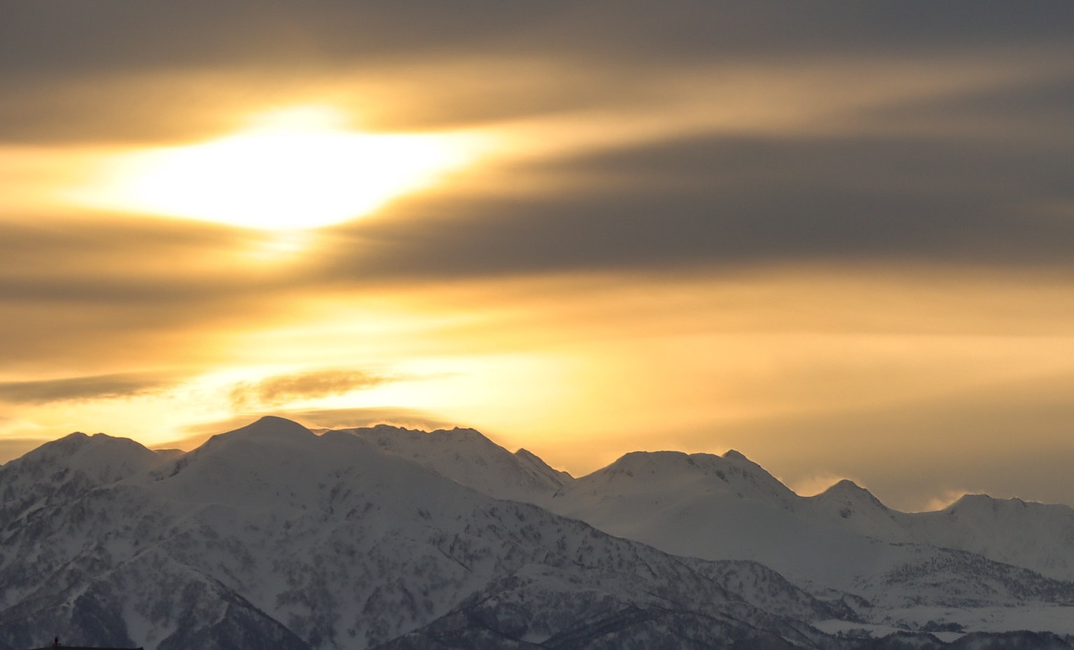 Schneebedeckte Berge, die von einem wunderschönen Sonnenuntergang beleuchtet werden