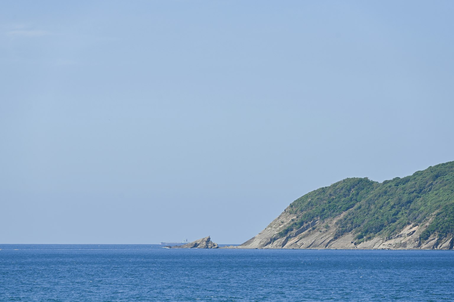 Paysage avec une mer bleue et des montagnes vertes