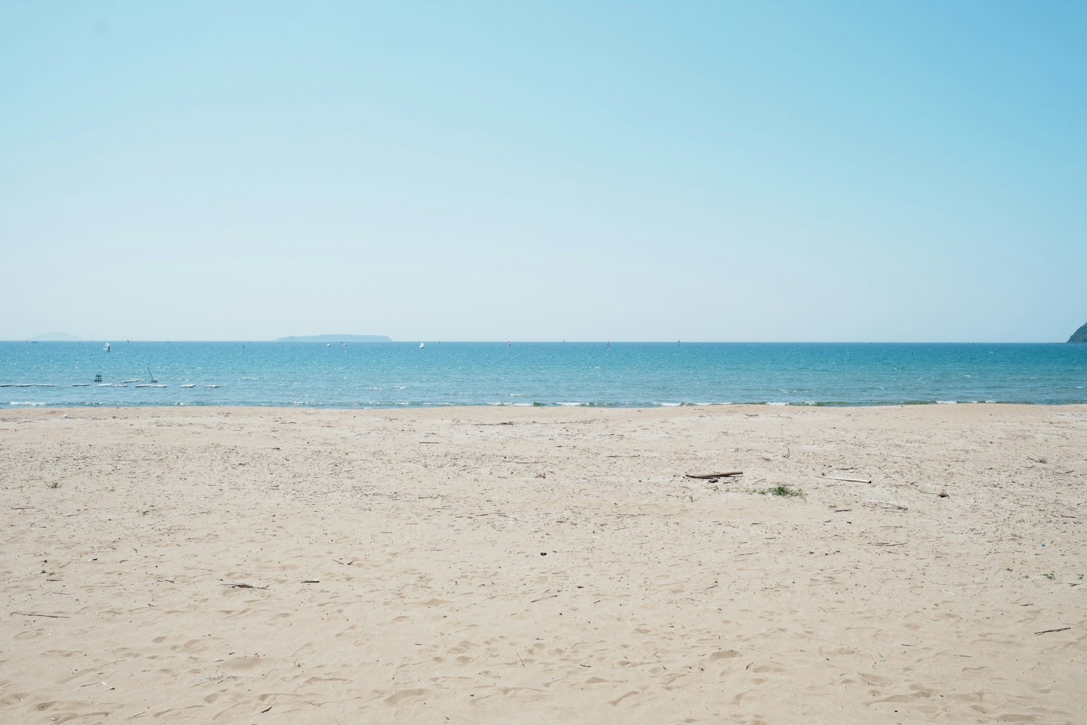 ทิวทัศน์ของทะเลสีน้ำเงินและชายหาดทรายสว่าง