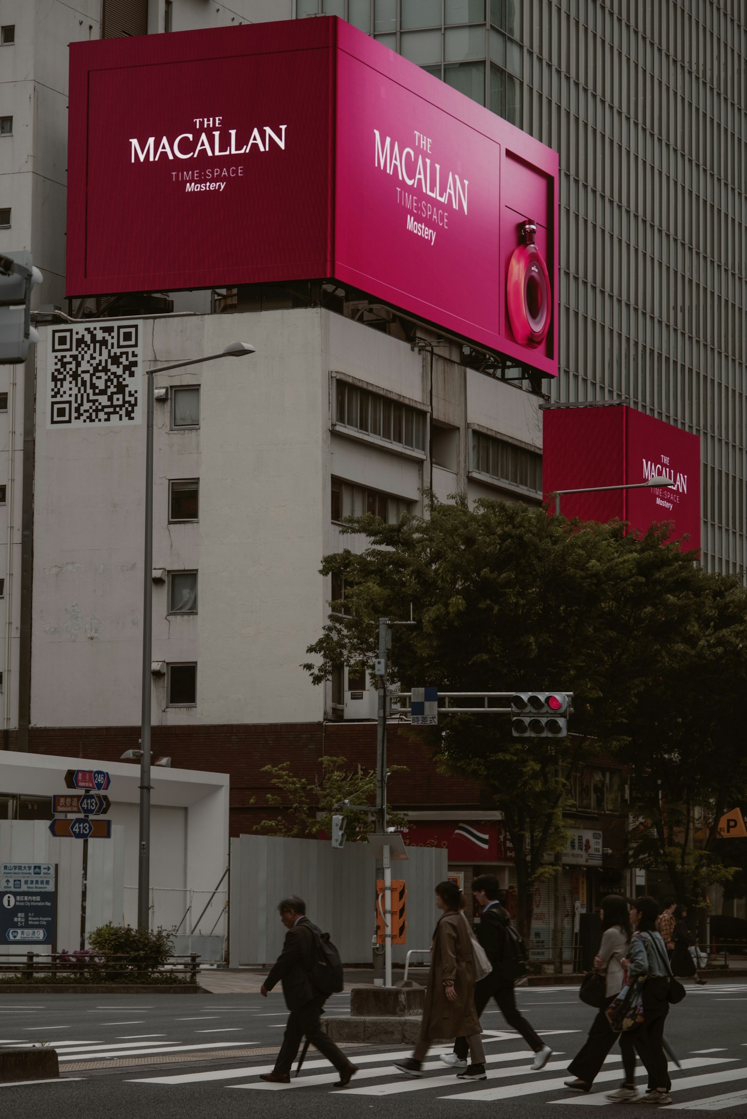 Large Macallan billboard in Tokyo with pedestrians crossing the street