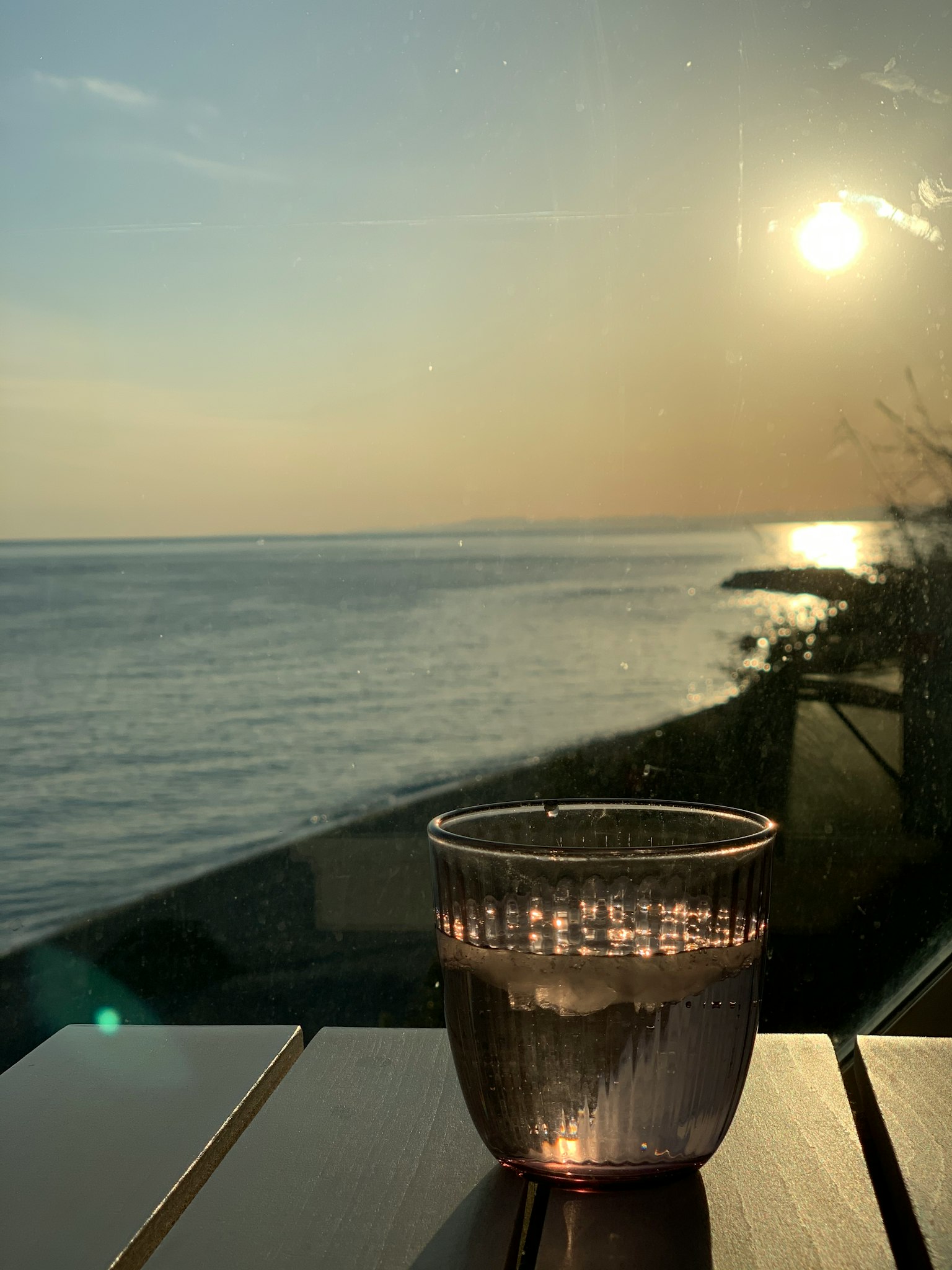 一个透明的水杯在海上日落前