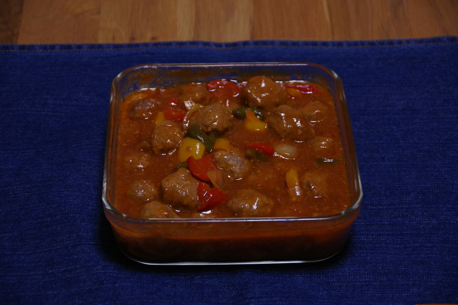 一個玻璃容器裝滿了色彩豐富的蔬菜和肉丸炖菜