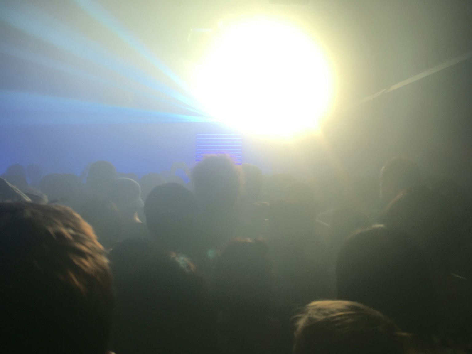 Foule à une fête avec des faisceaux lumineux créant une ambiance dynamique