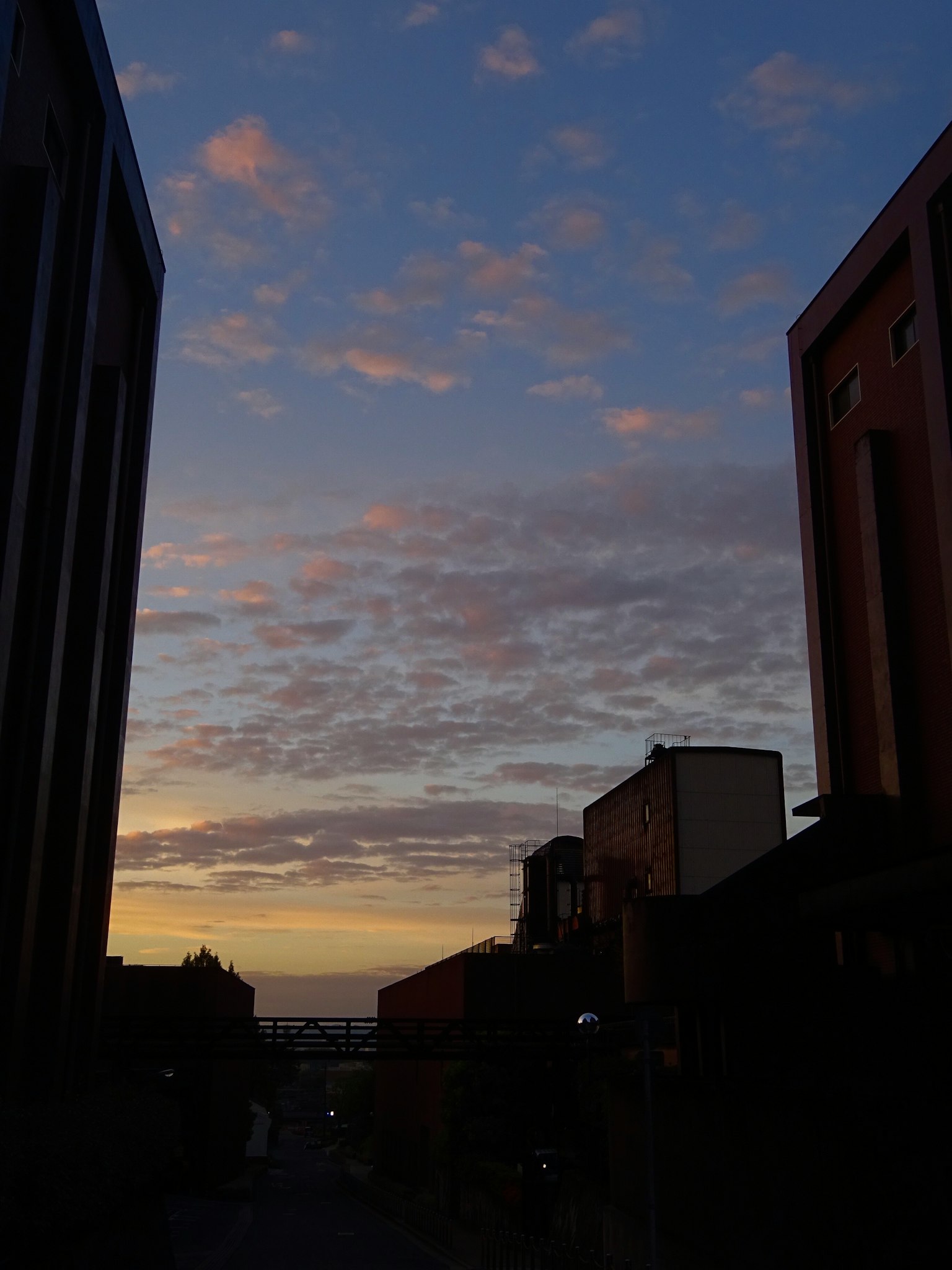 Silhouette of buildings against a colorful sunset sky