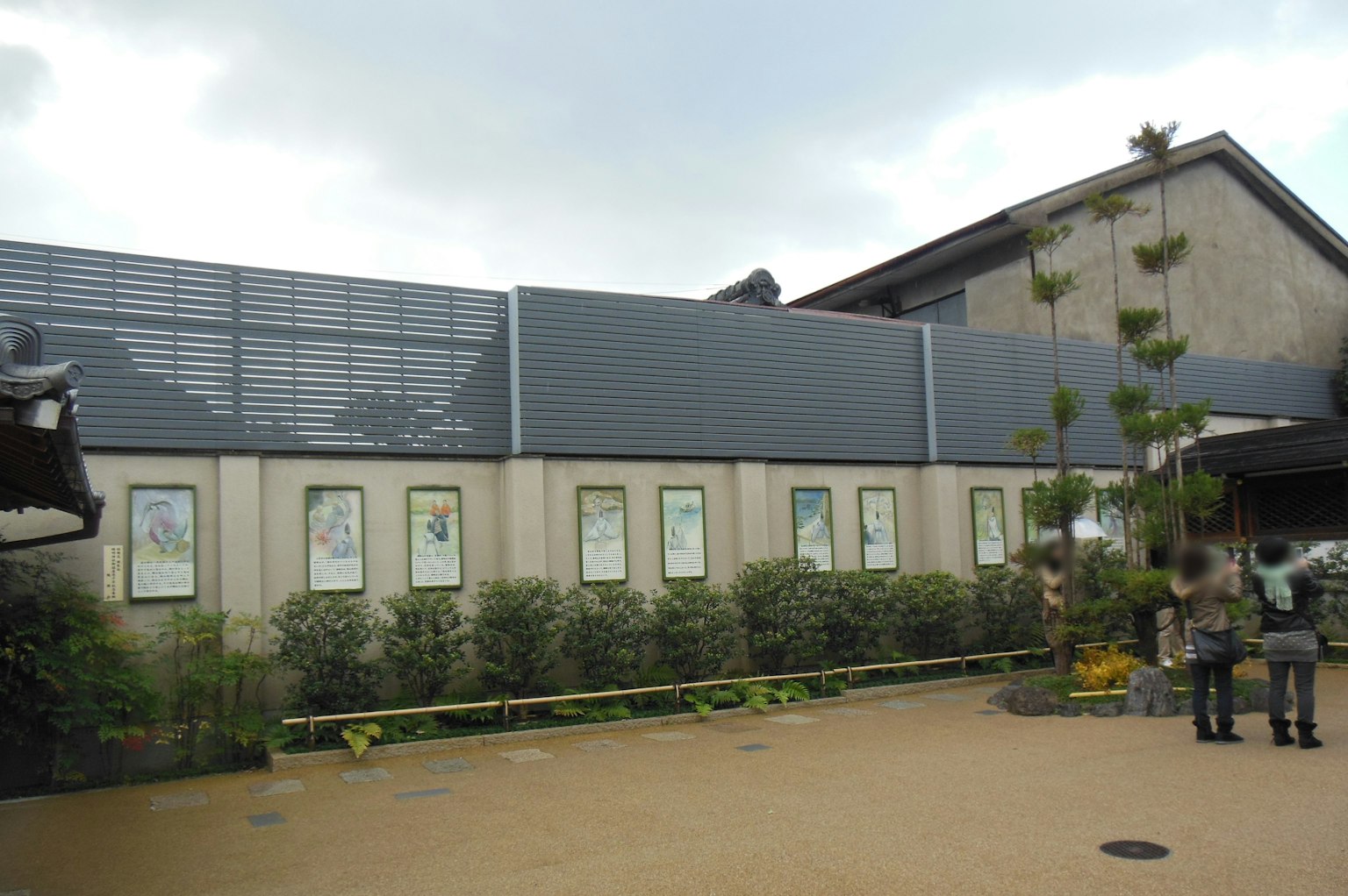 Extérieur d'un bâtiment moderne présentant des œuvres d'art et des plantes vertes