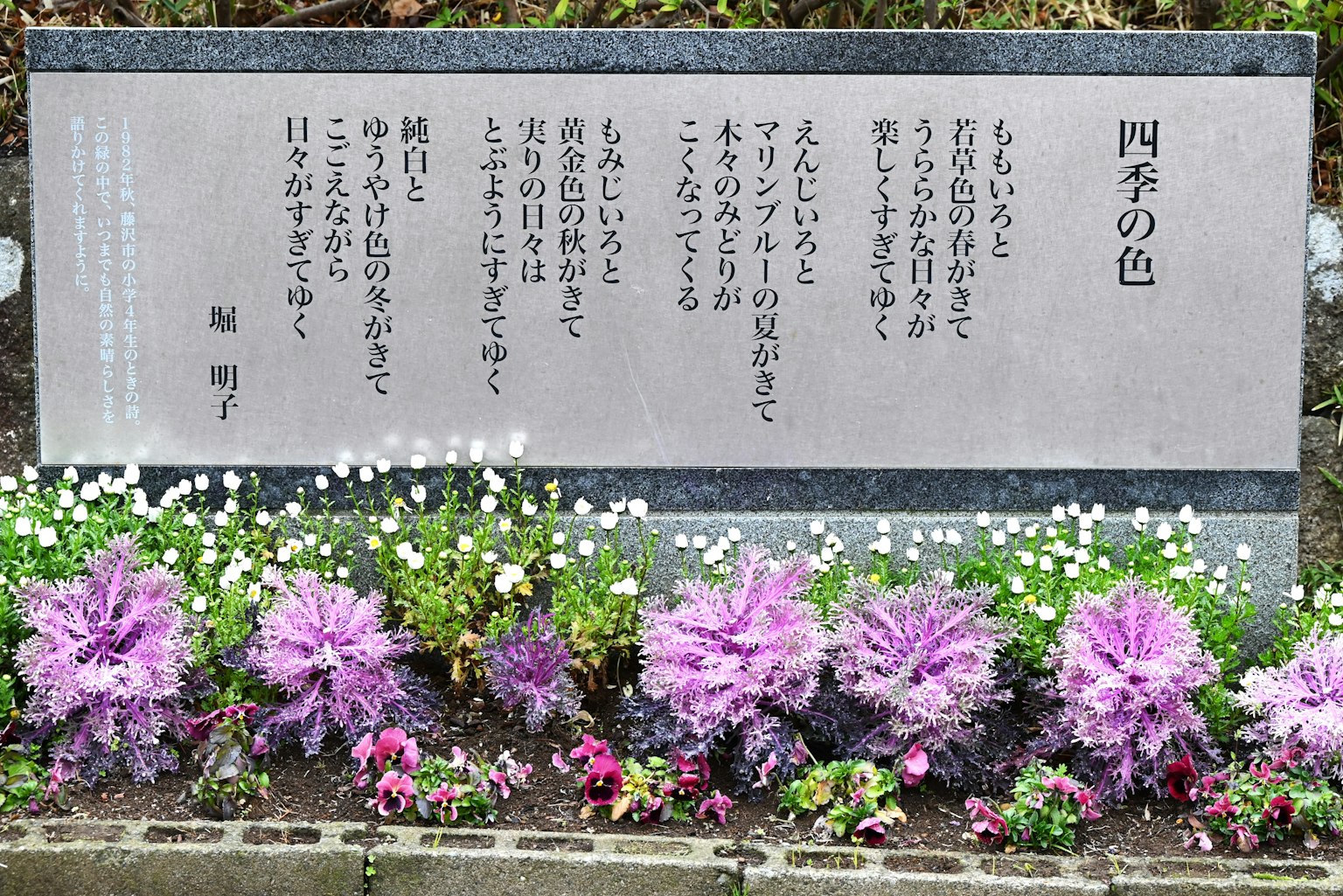石碑上刻有诗歌的花坛前景