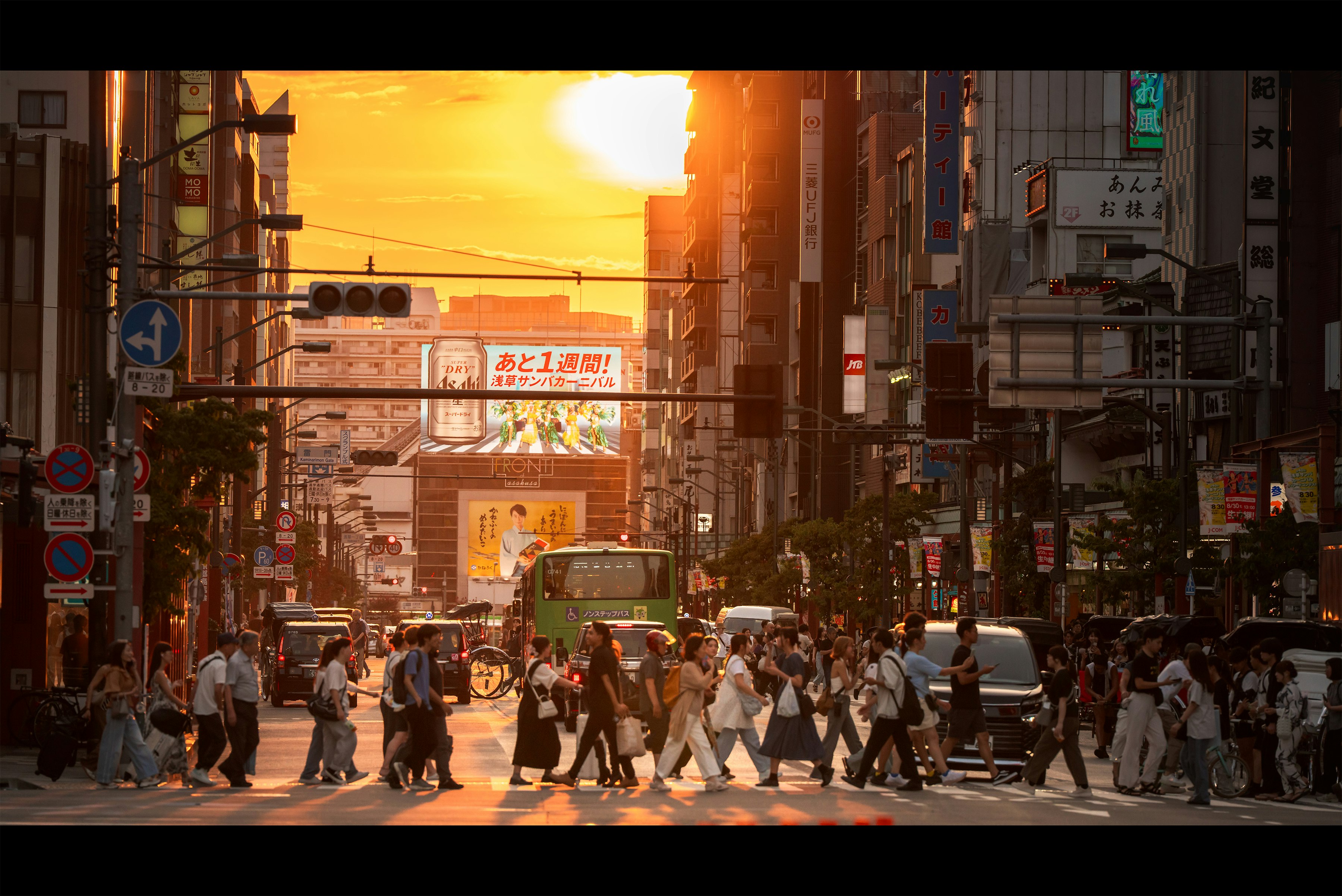 夕焼けの街並みを行き交う人々の多い通り