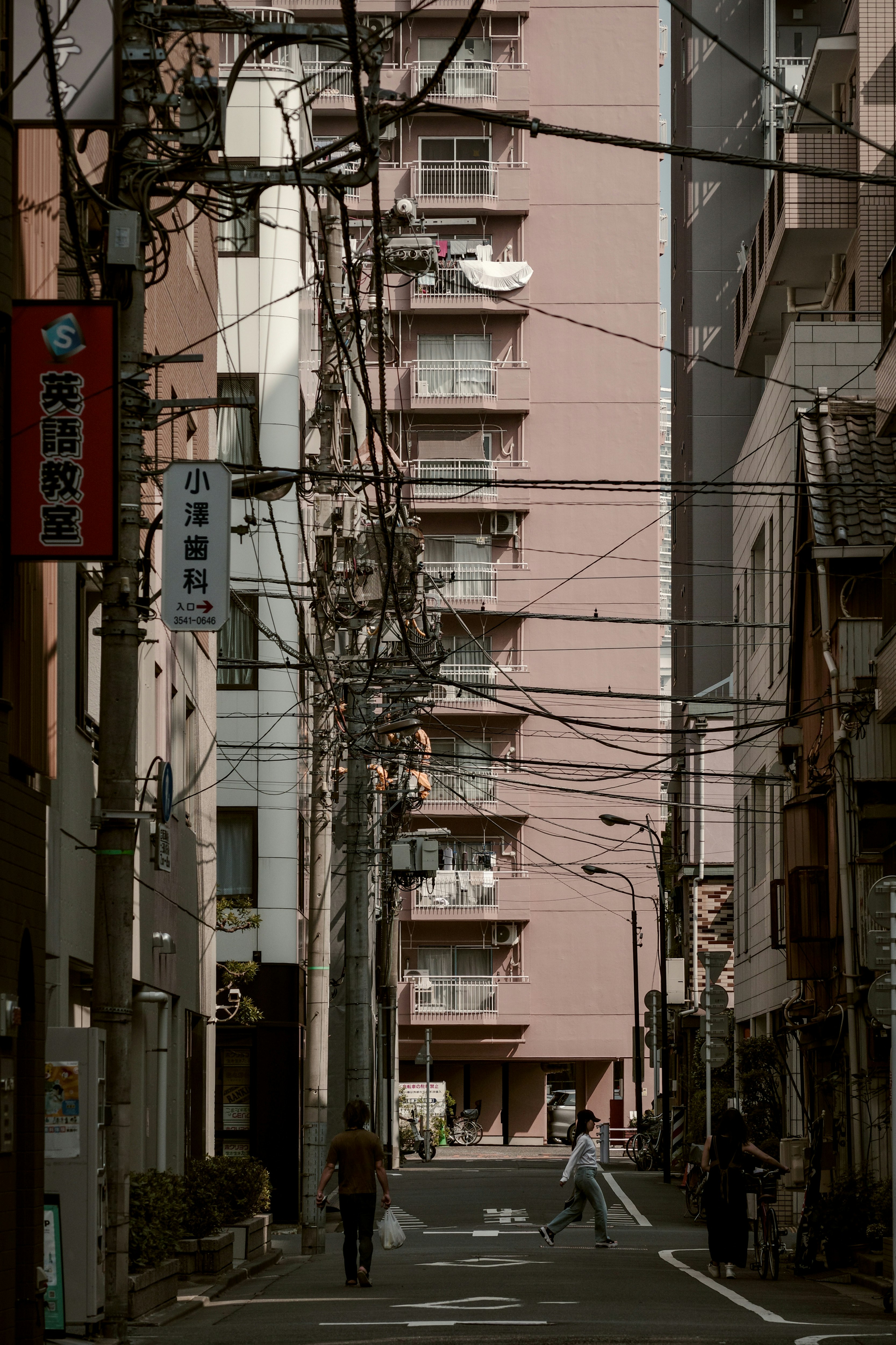 下町の路地に並ぶ電線と集合住宅の街並み