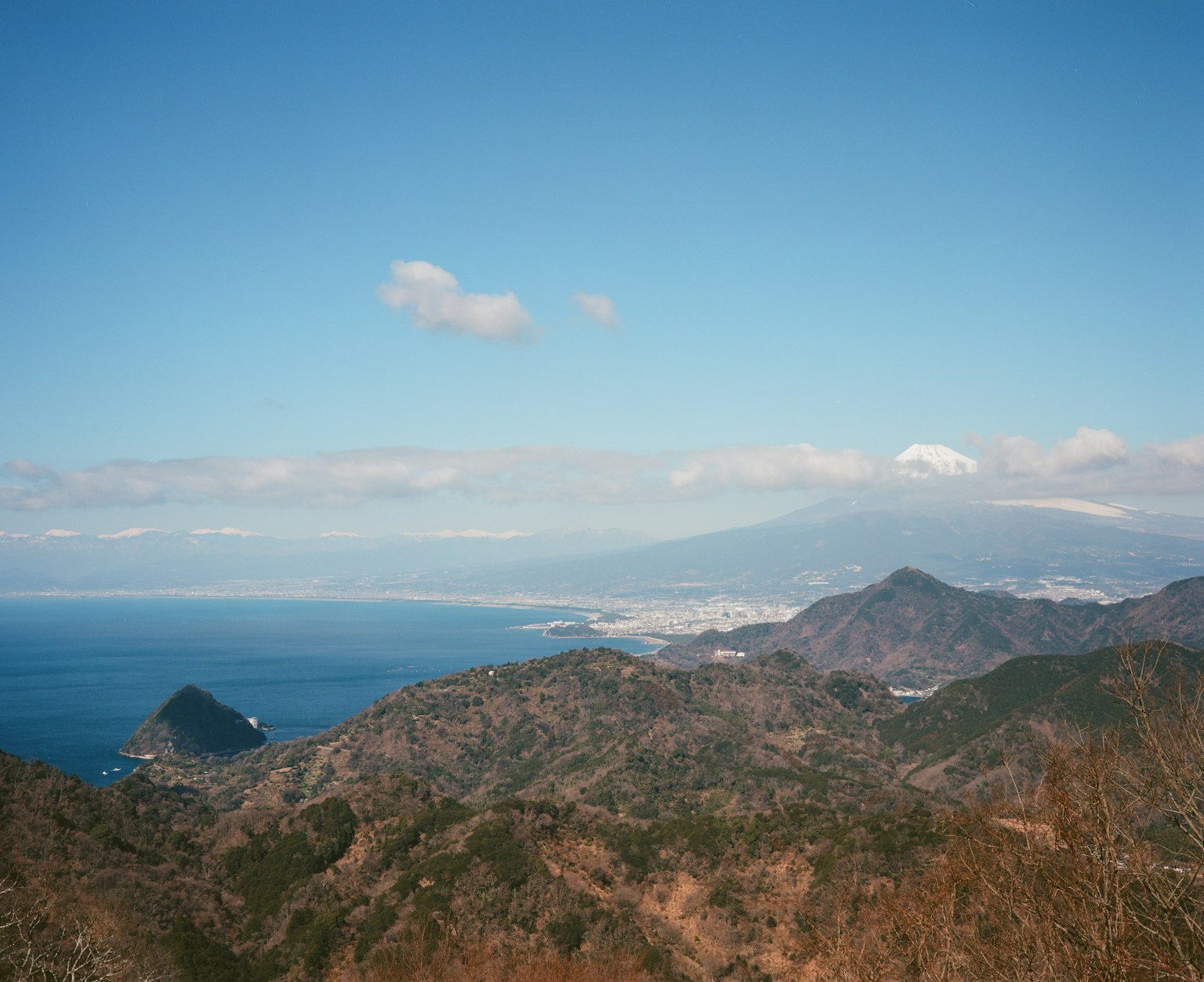 Vista panoramica di montagne e oceano sotto un cielo blu