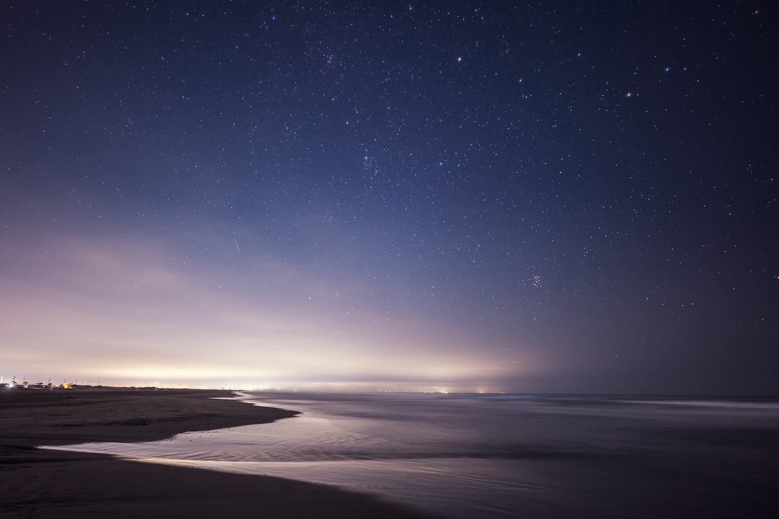 Küstenlandschaft bei Nacht mit Sternen am Himmel