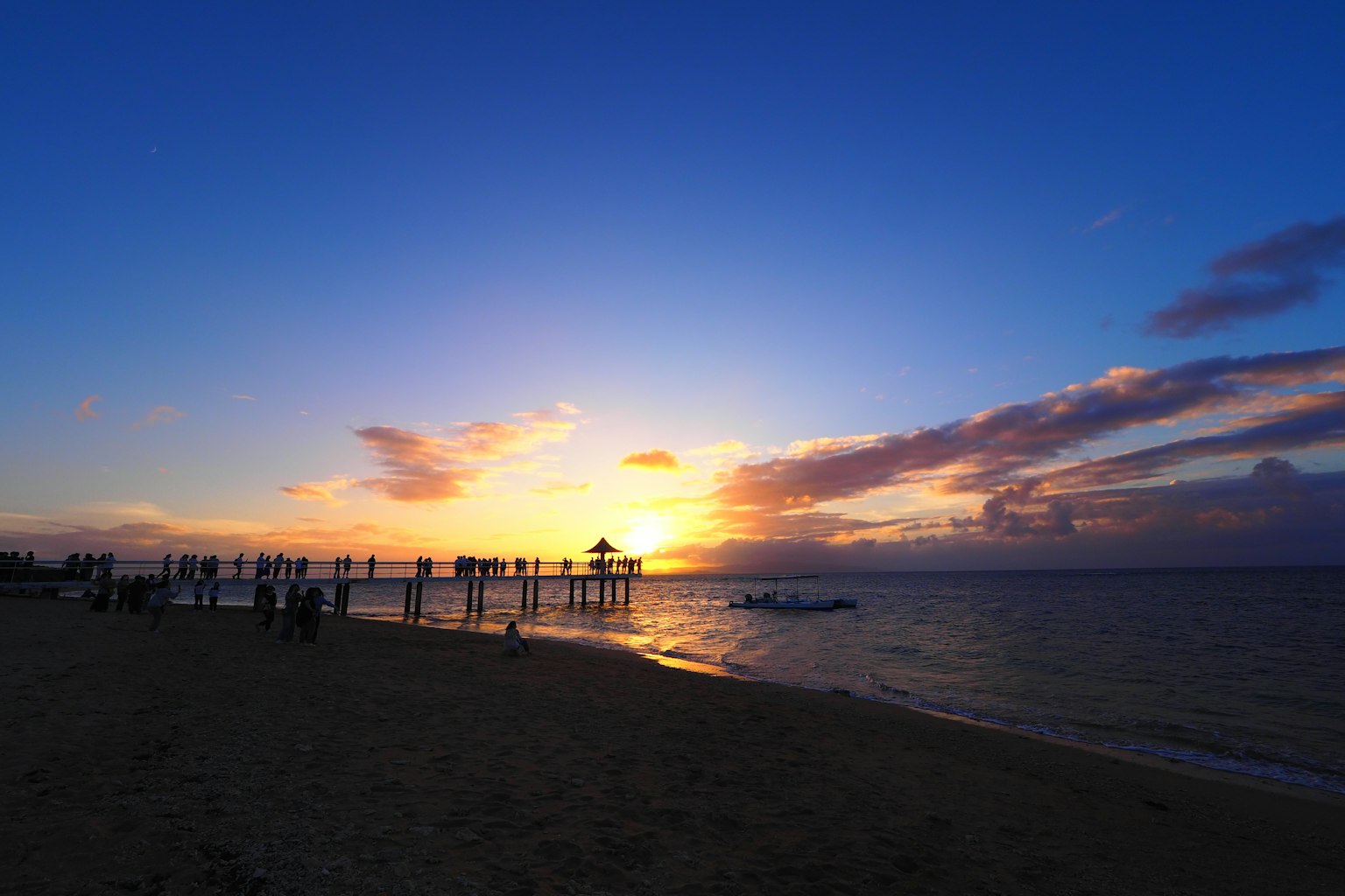 Hermoso atardecer sobre el océano con un muelle y una playa
