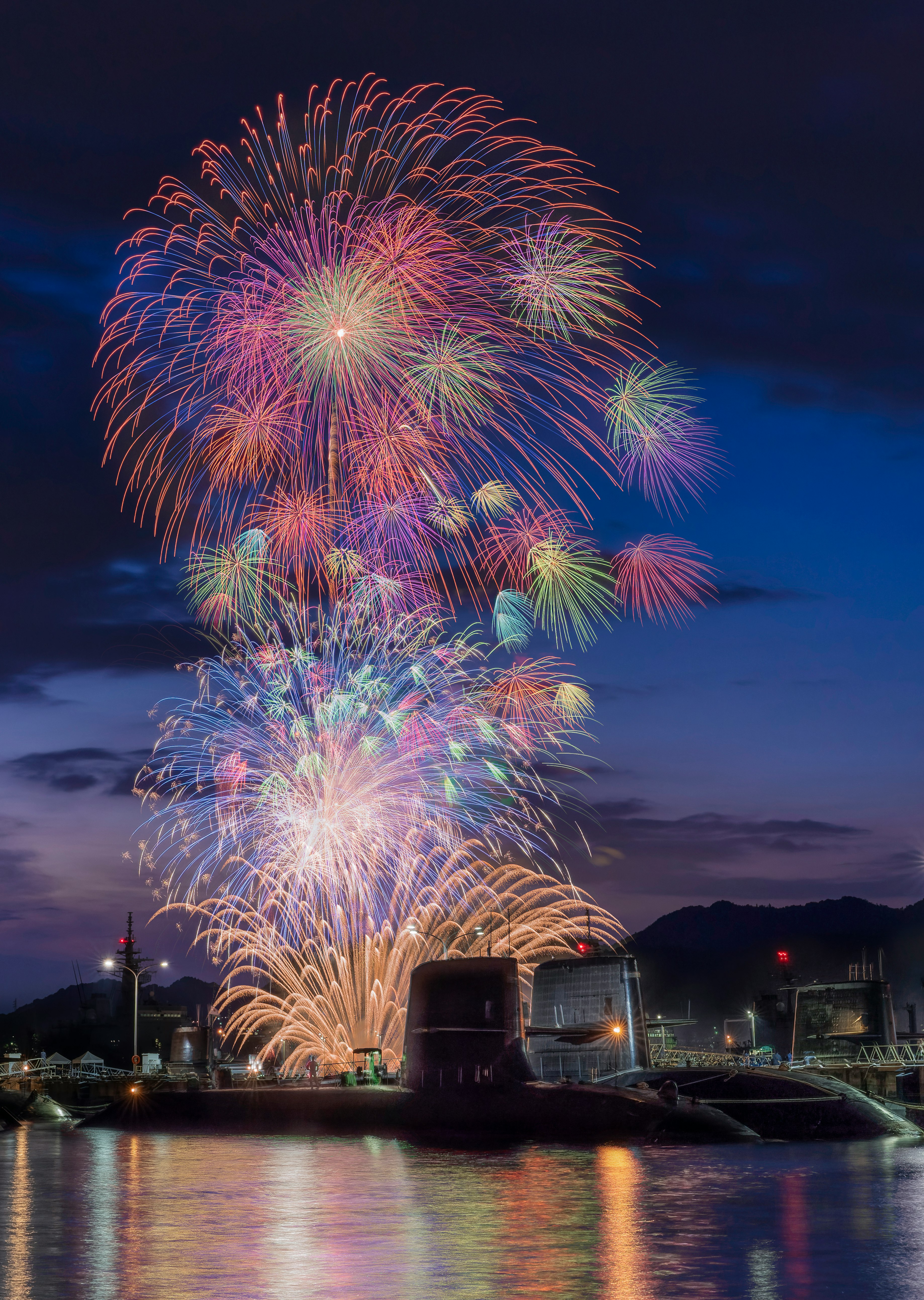 Colorful fireworks display in the night sky reflecting on the water