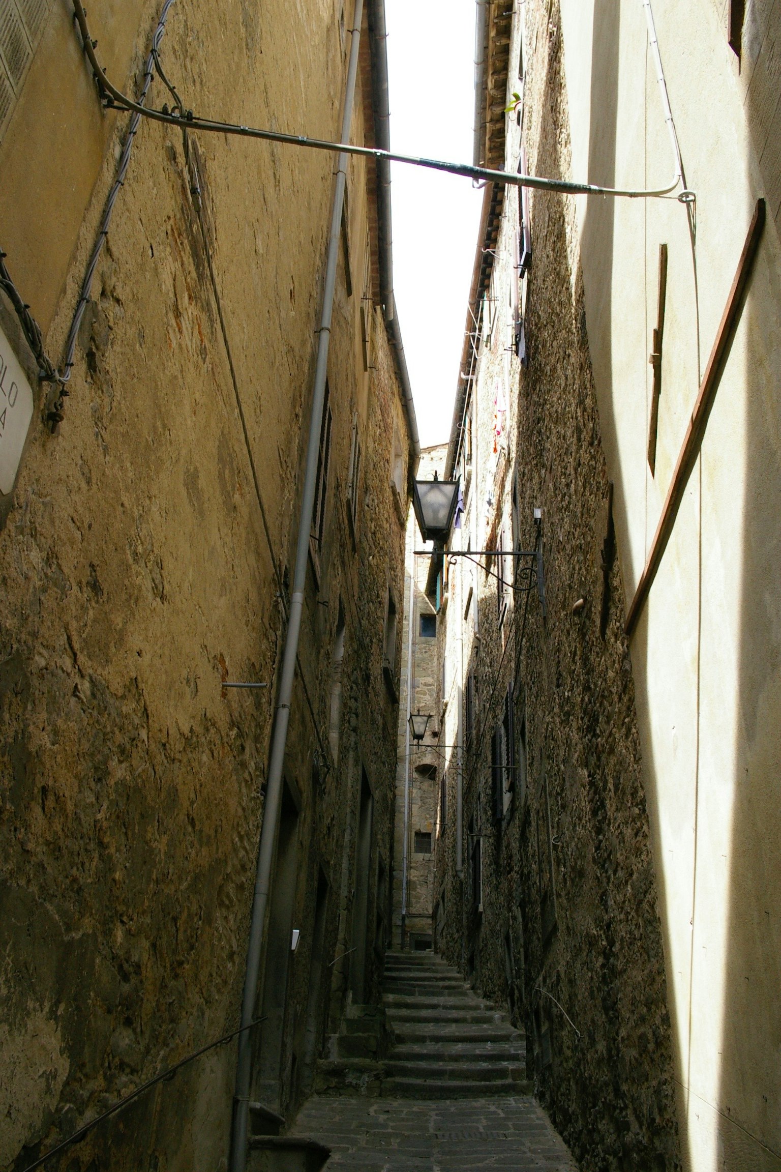 Vicolo stretto in pietra circondato da edifici antichi