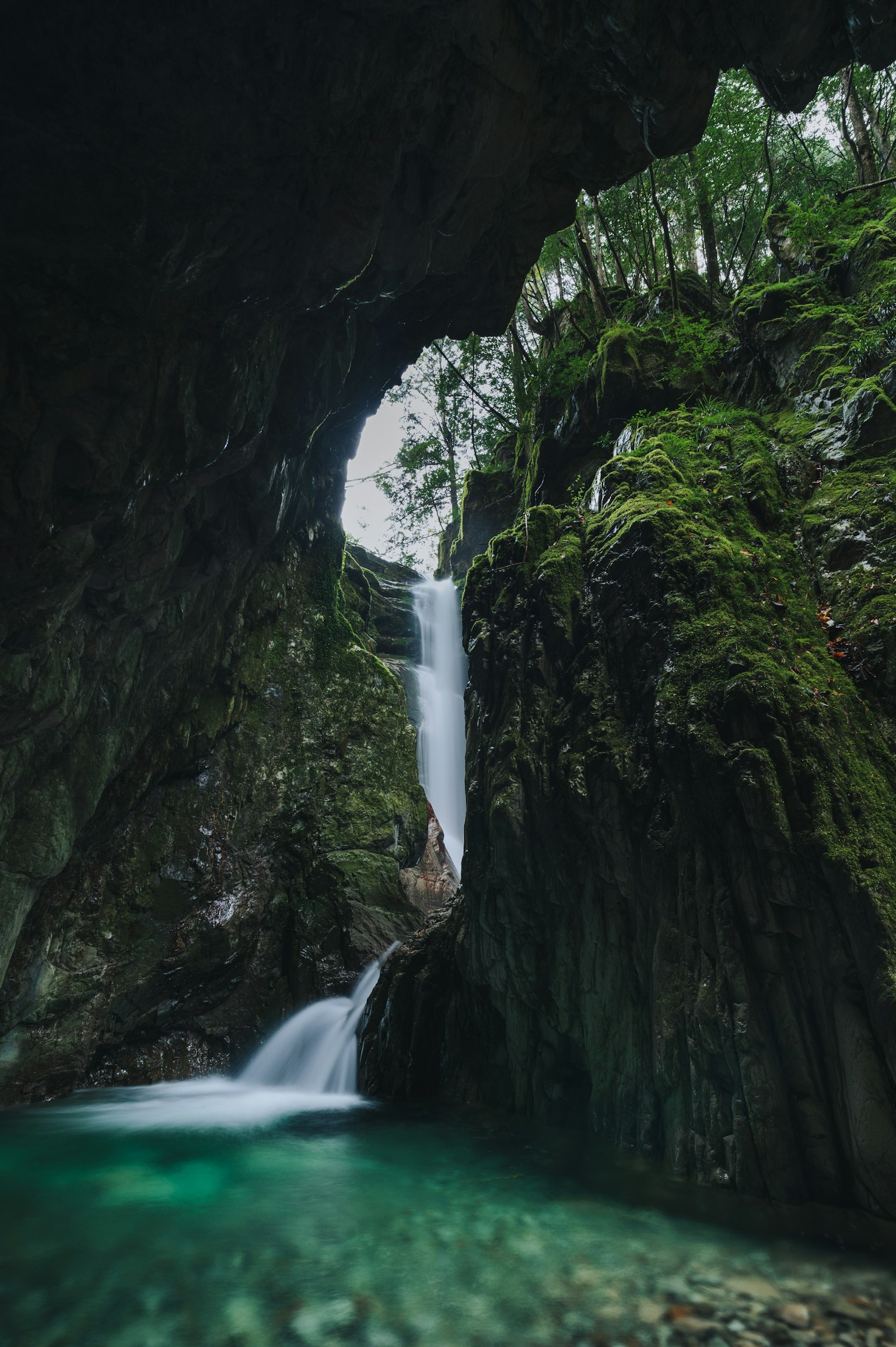 Una vista mozzafiato di una cascata che scorre tra rocce coperte di muschio
