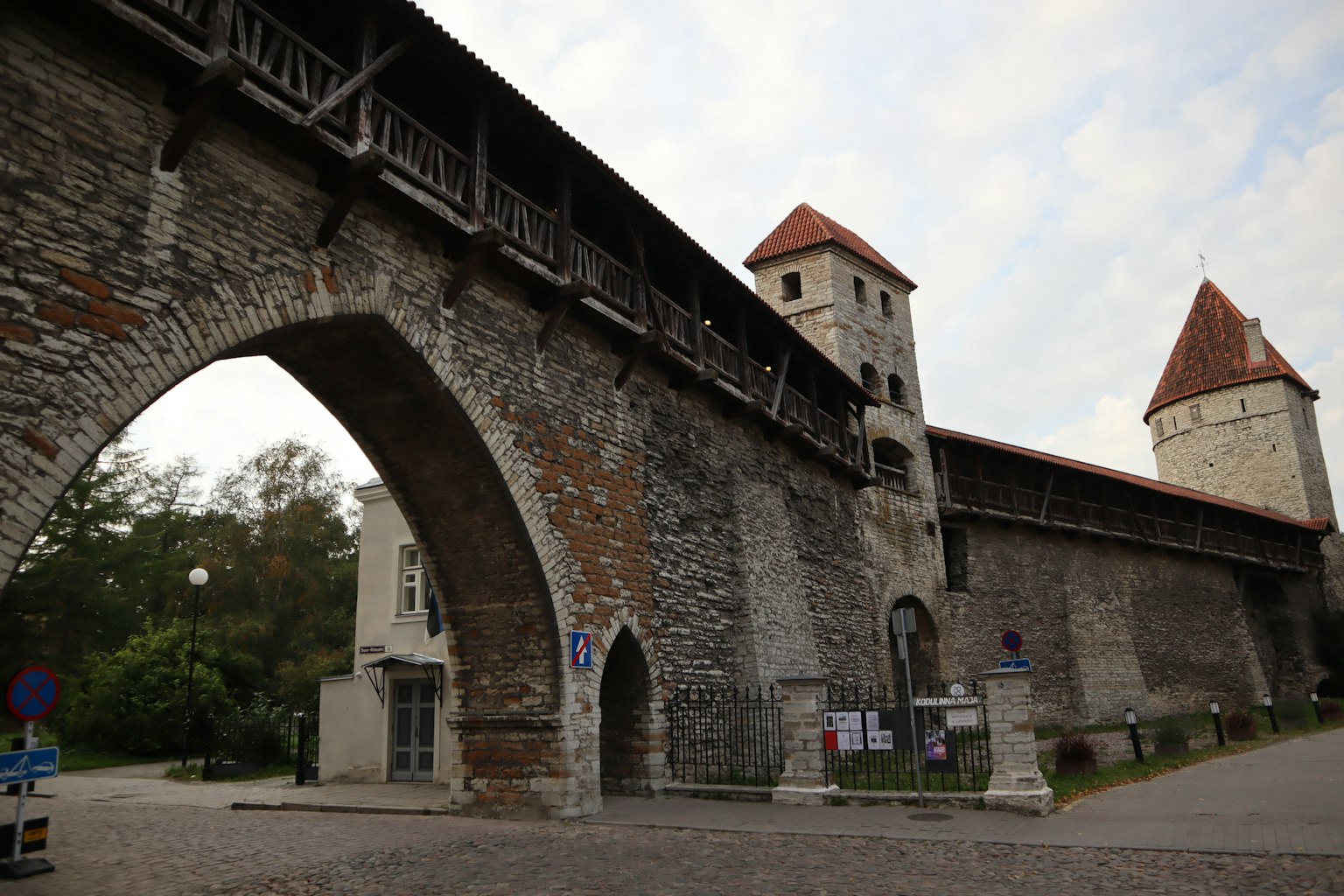 Mittelalterliche Stadtmauer mit Türmen und einem gewölbten Eingang sowie einem Holzsteg