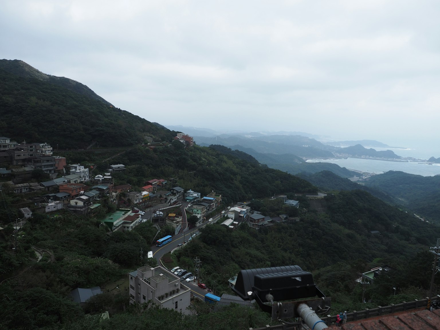 Vista nublada de un paisaje montañoso con casas dispersas