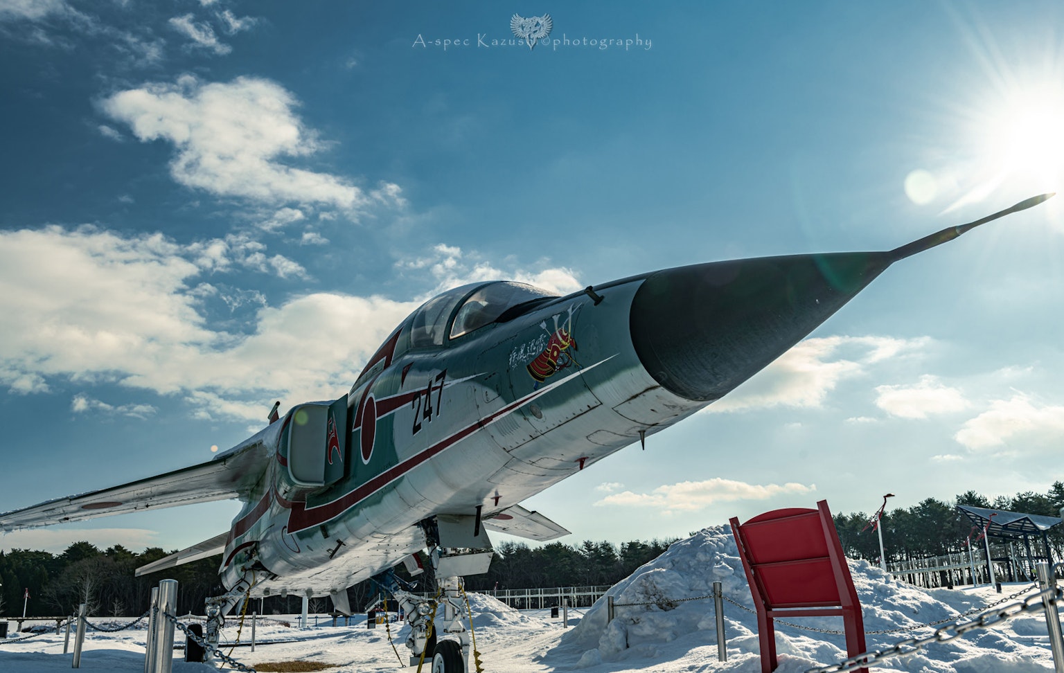 Seitenansicht eines Kampfjets auf Schnee mit blauem Himmel