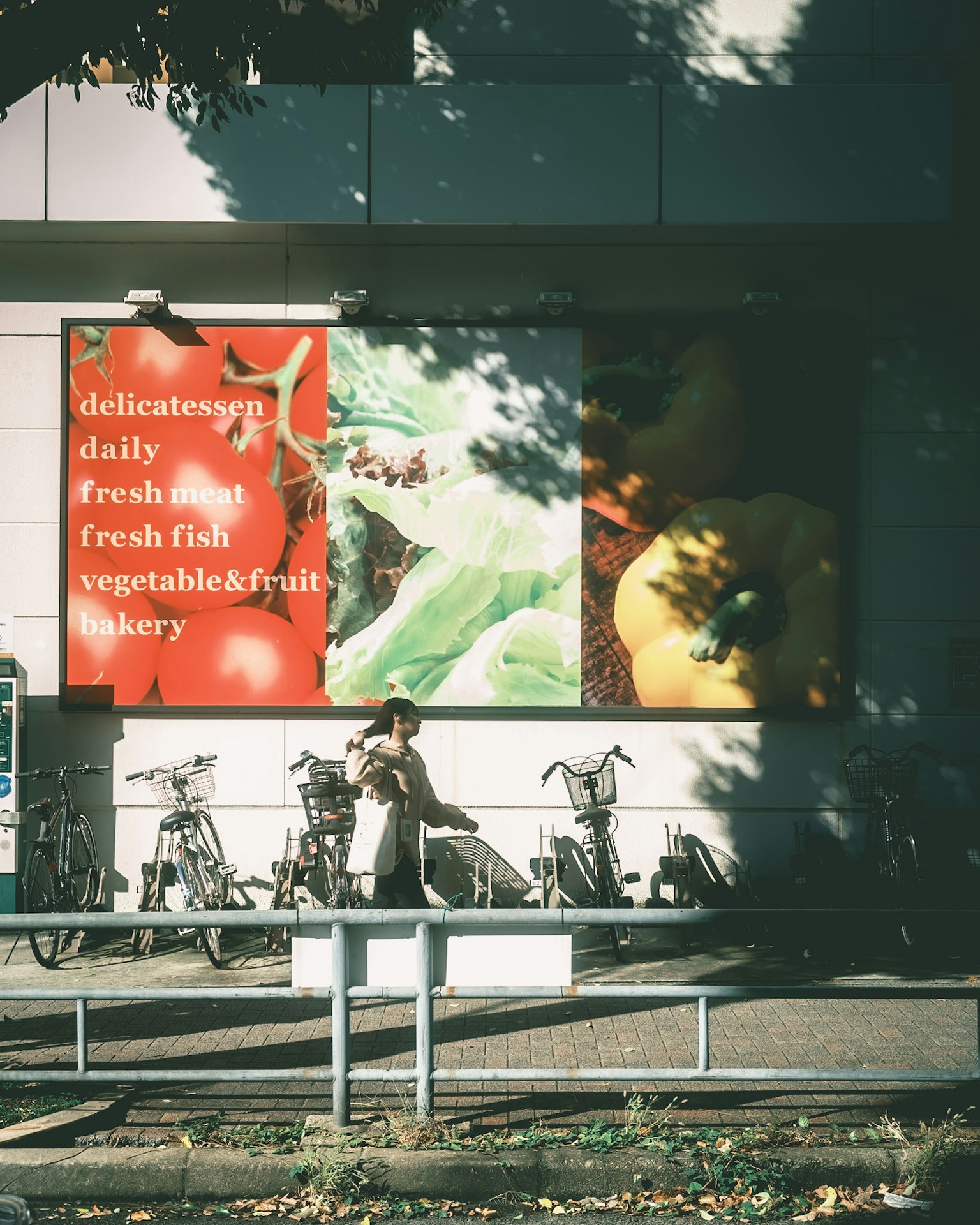Exterior de una tienda con un anuncio de productos frescos y bicicletas estacionadas cerca