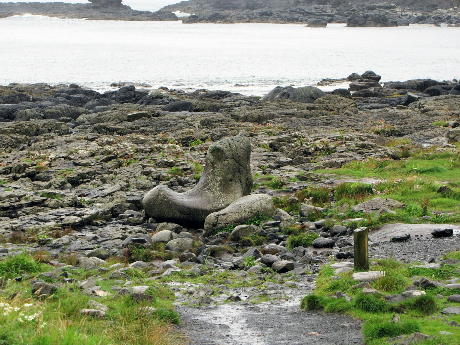 Formation en pierre de grande taille semblable à une sculpture sur une côte rocheuse