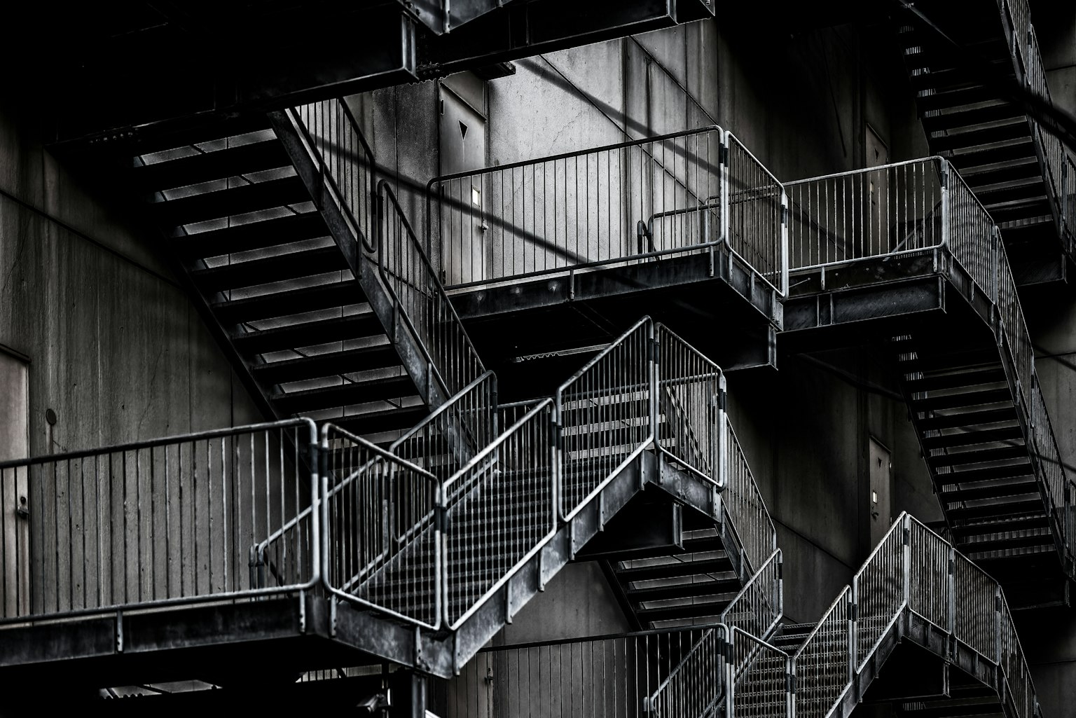 Une photo d'escaliers en métal entrecroisés avec des rampes