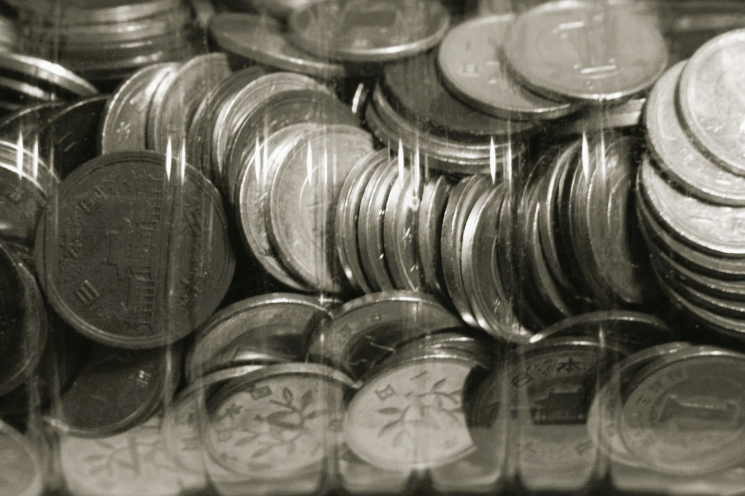 Tampilan dekat koin yang ditumpuk dalam hitam putih