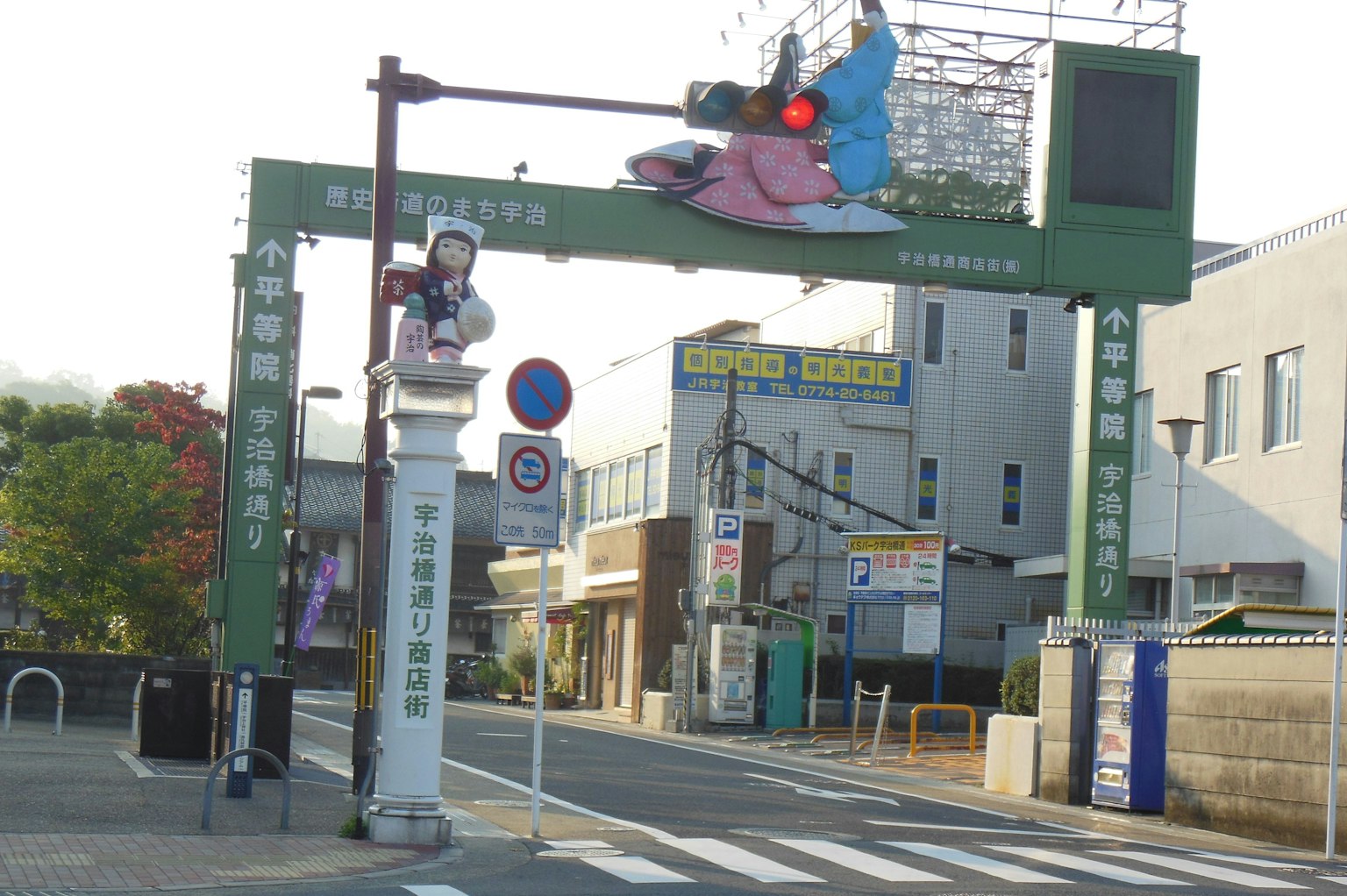 Ingresso ad arco verde con semaforo e paesaggio urbano