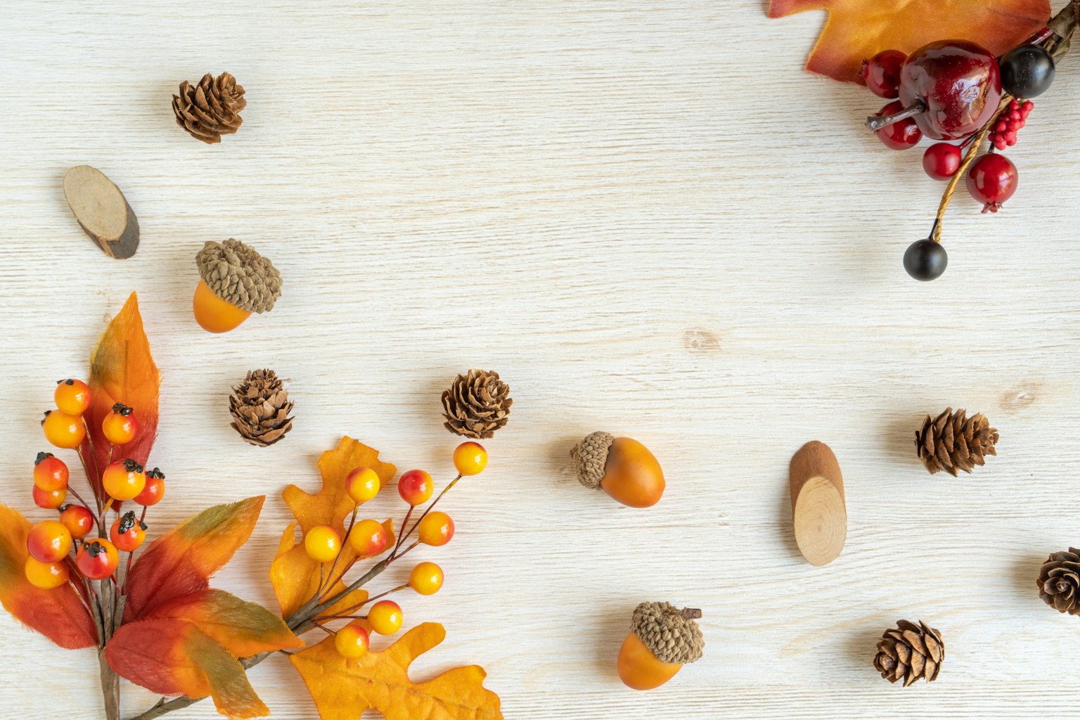 Feuilles d'automne et pommes de pin éparpillées sur une surface en bois
