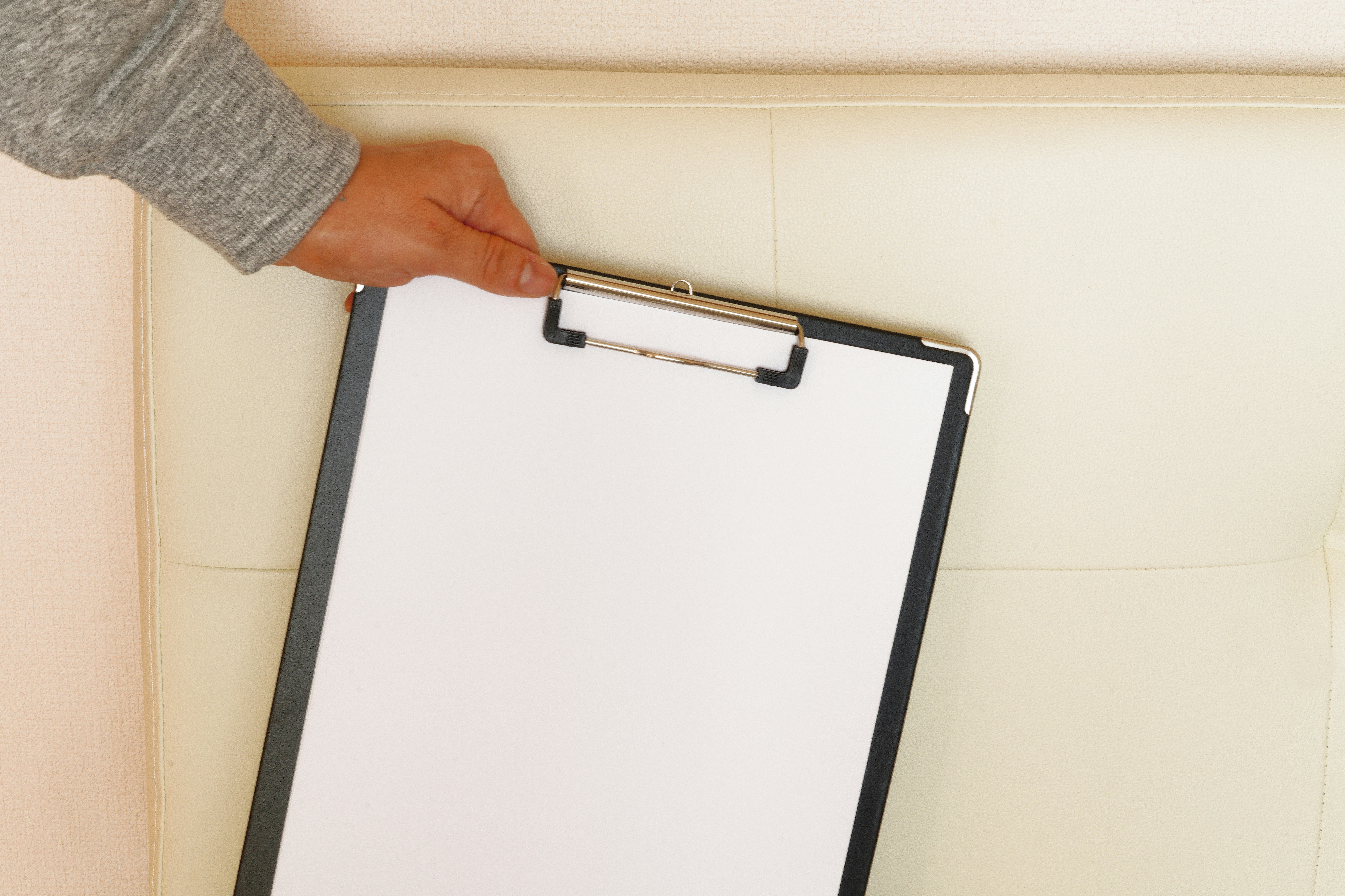 hand holding a clipboard in an office-like setting