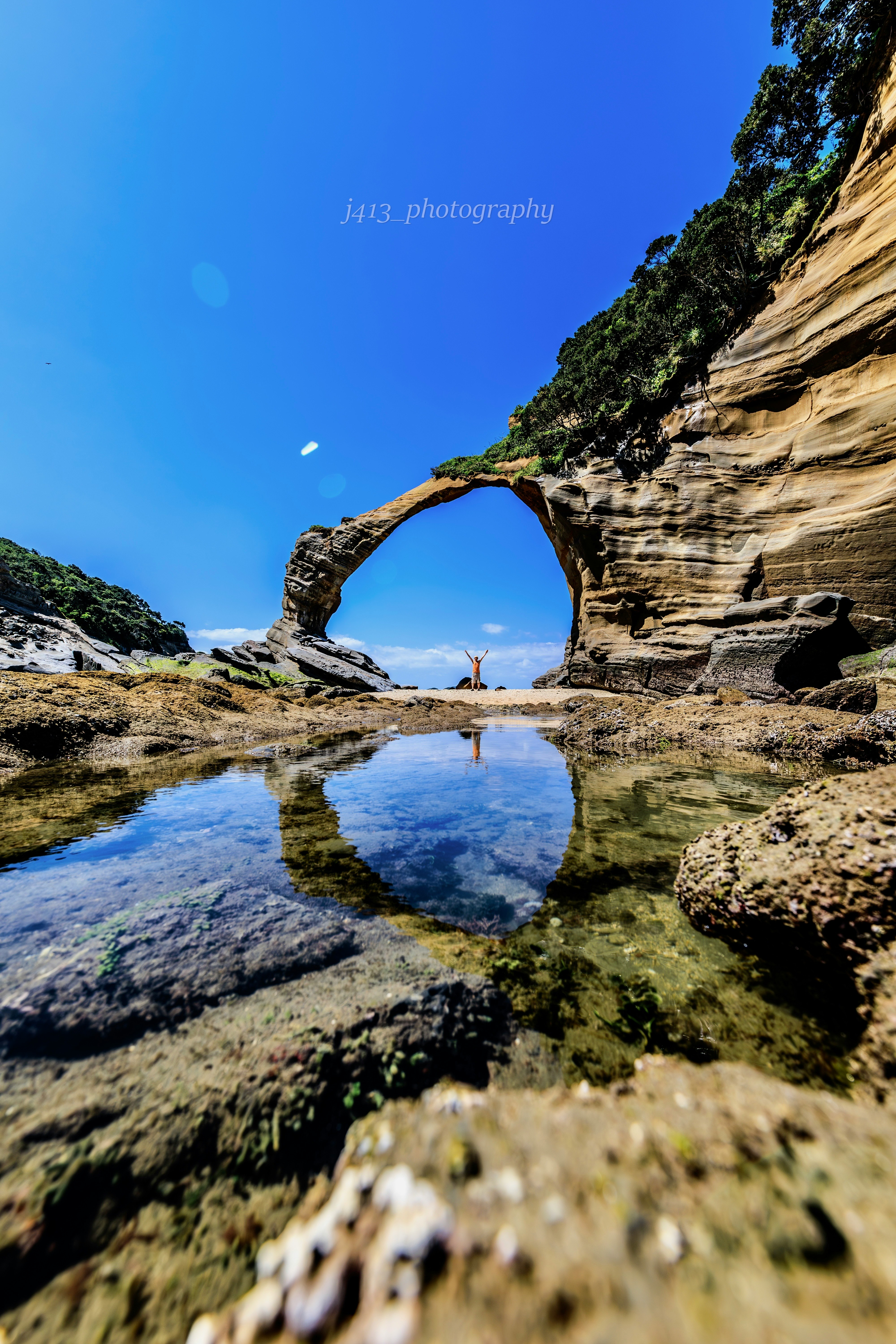 種子島の岩屋アーチと海に映る水たまりの景観