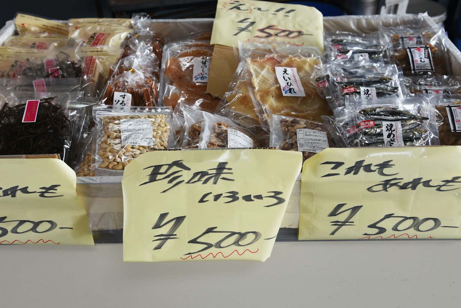 Snacks envasados expuestos en una mesa con etiquetas de precio