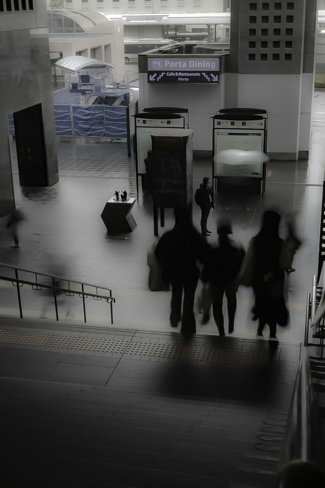 Menschen gehen durch einen Korridor im Bahnhofsgebäude