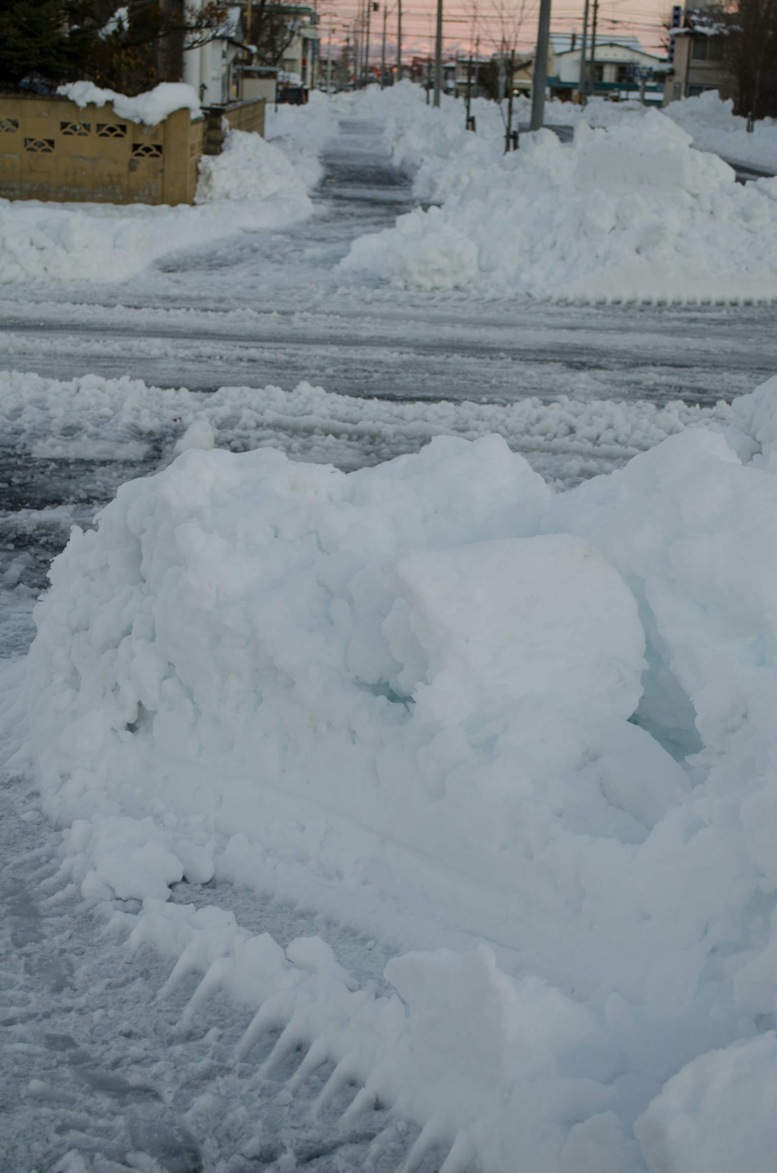 被雪覆盖的道路和雪堆以及轮胎痕迹
