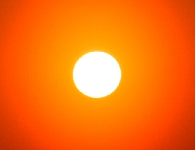 夕焼けのオレンジ空に浮かぶ太陽