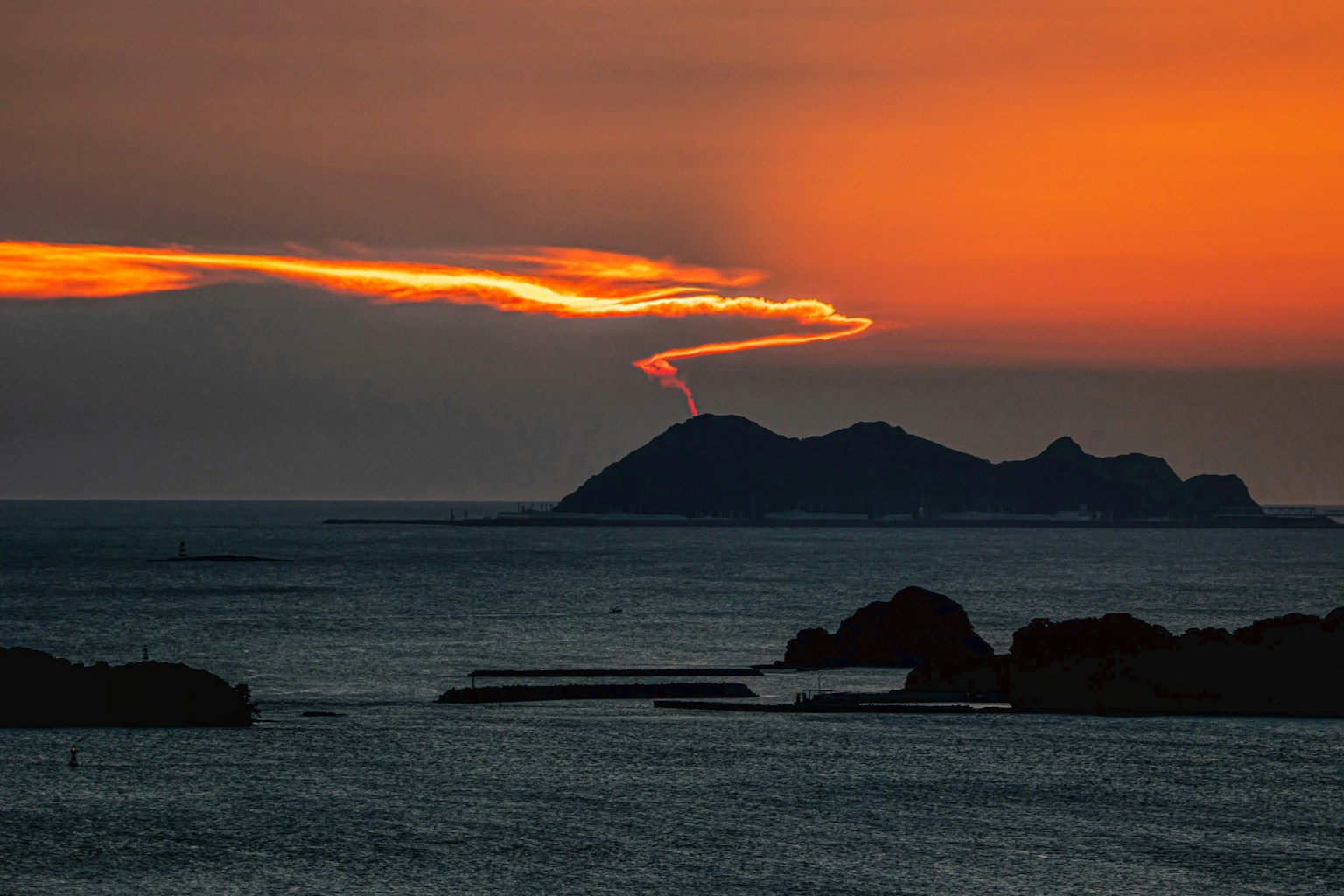 海上日落，橙色天空和轮廓岛屿