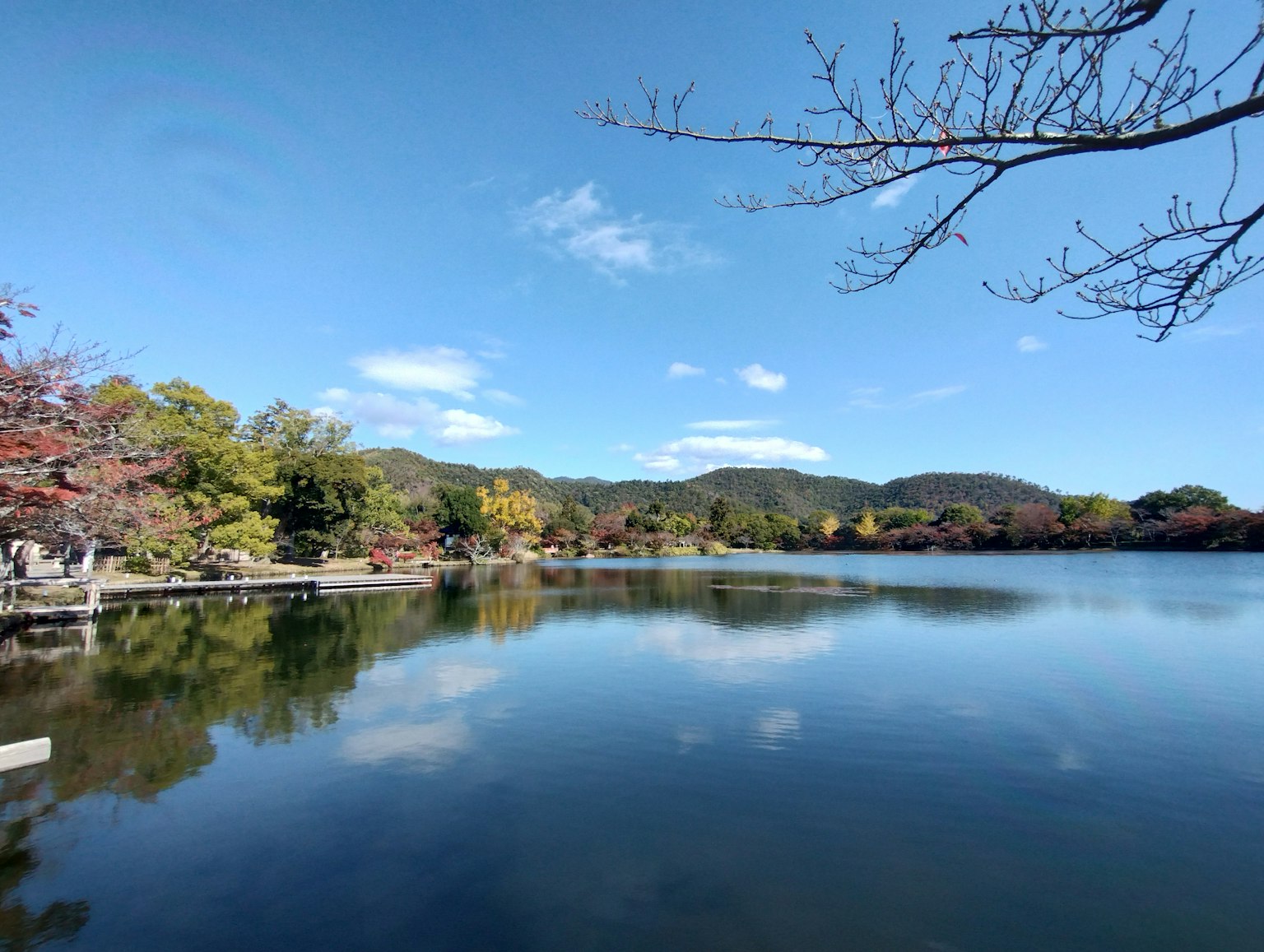 Malersicher Blick auf einen See und blauen Himmel ruhiges Wasser spiegelt Berge und Herbstlaub wider