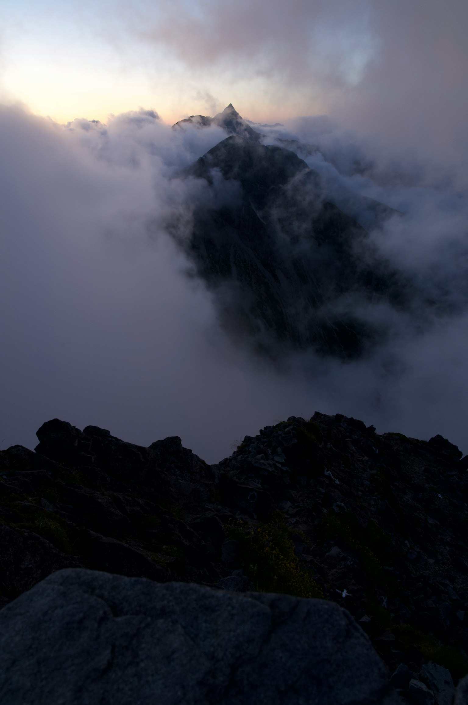 霧中顯現的山峰與岩石前景