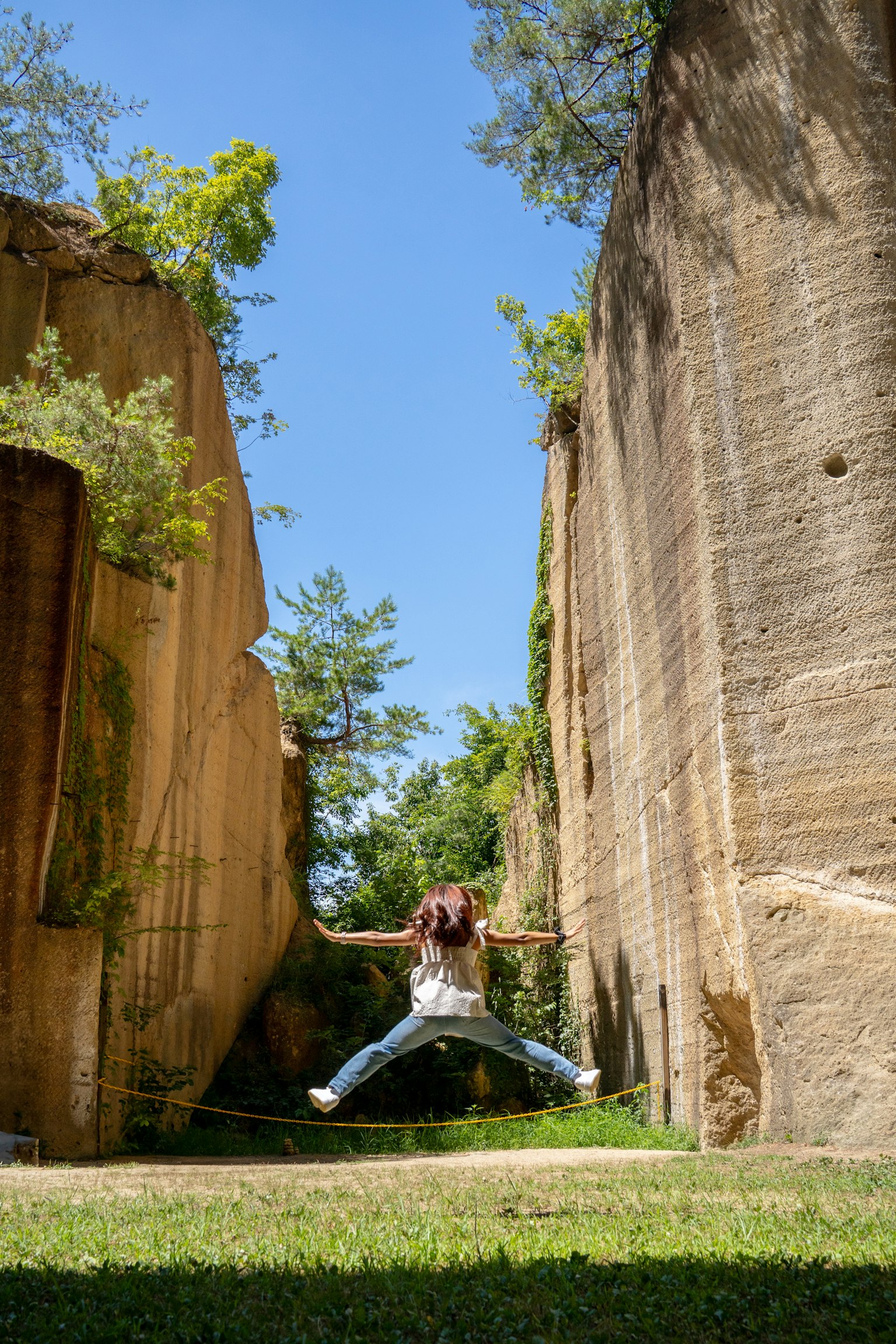 Người nhảy giữa các khối đá dưới bầu trời xanh