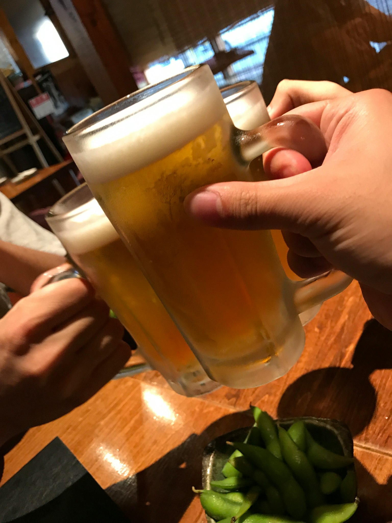 Hands clinking glasses of beer in a celebratory toast
